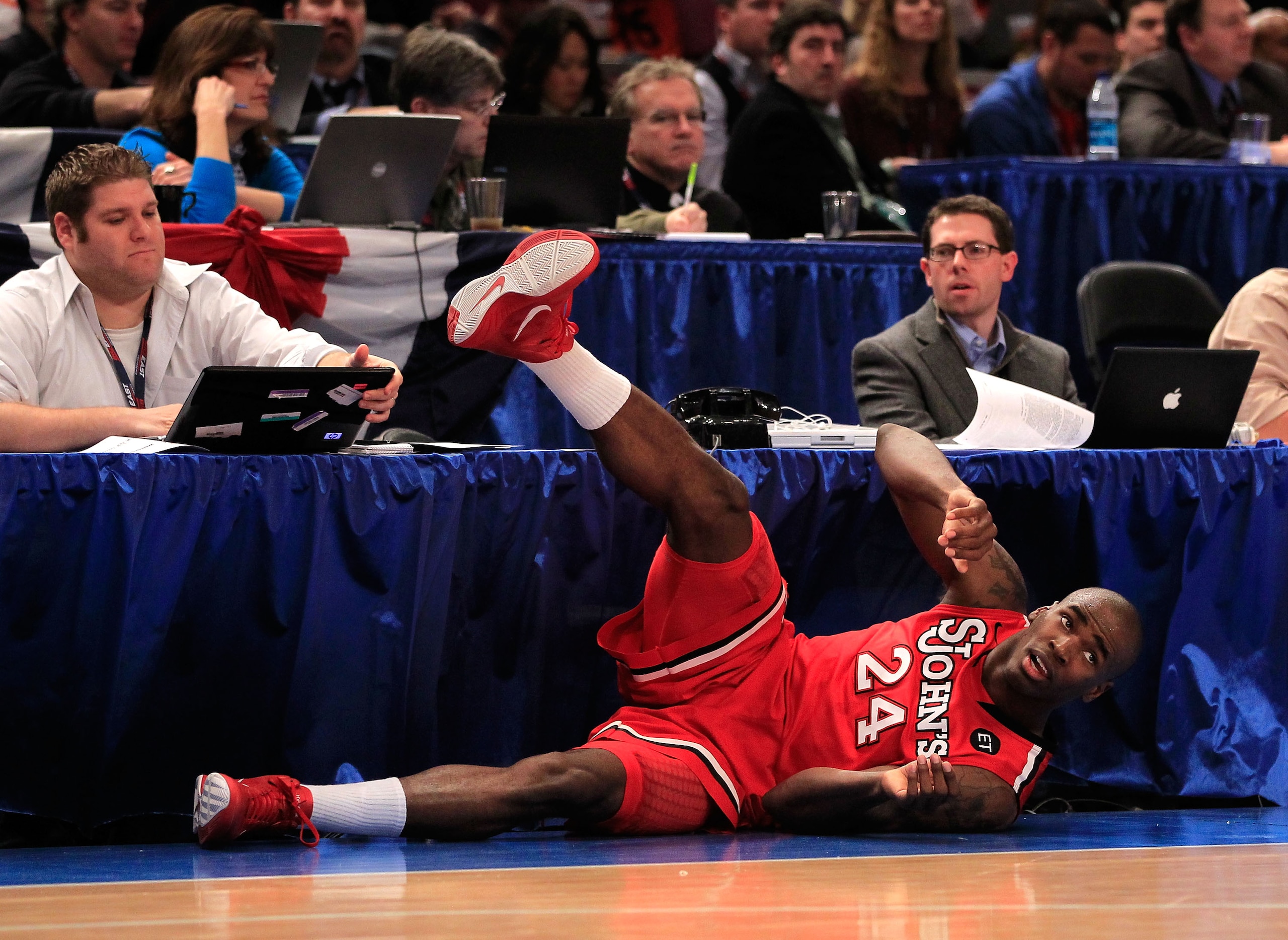 NEW YORK, NY - MARCH 10:  Justin Burrell #24 of the St. John's Red Storm looks up after falling into a press table against the Syracuse Orange during the quarterfinals of the 2011 Big East Men's Basketball Tournament presented by American Eagle Outfitters