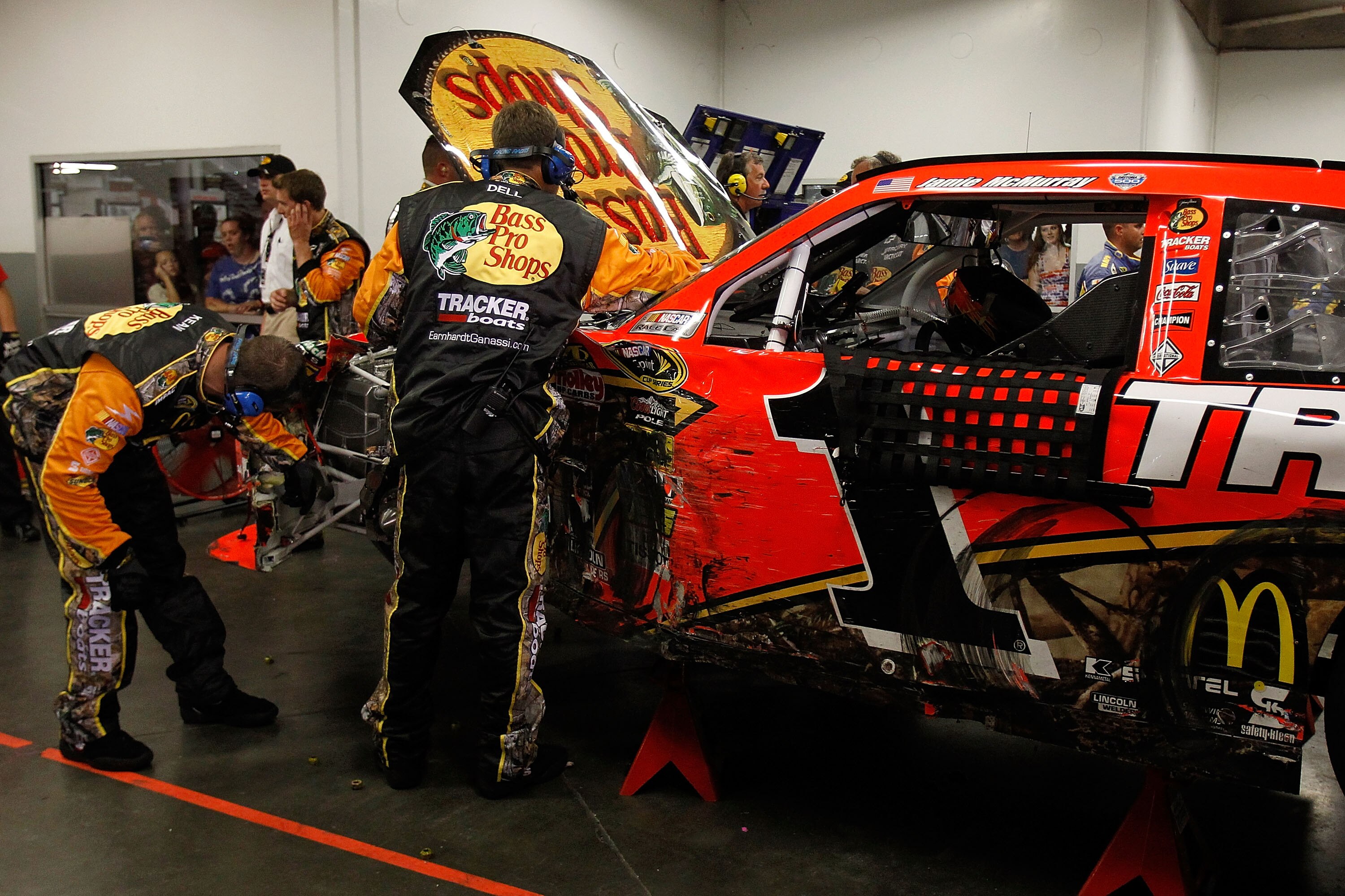 DAYTONA BEACH, FL - JULY 03:  Crew members work on the car of Jamie McMurray, driver of the #1 Bass Pro Shops/Tracker Chevrolet, after a crash during the NASCAR Sprint Cup Series Coke Zero 400 at Daytona International Speedway on July 3, 2010 in Daytona B