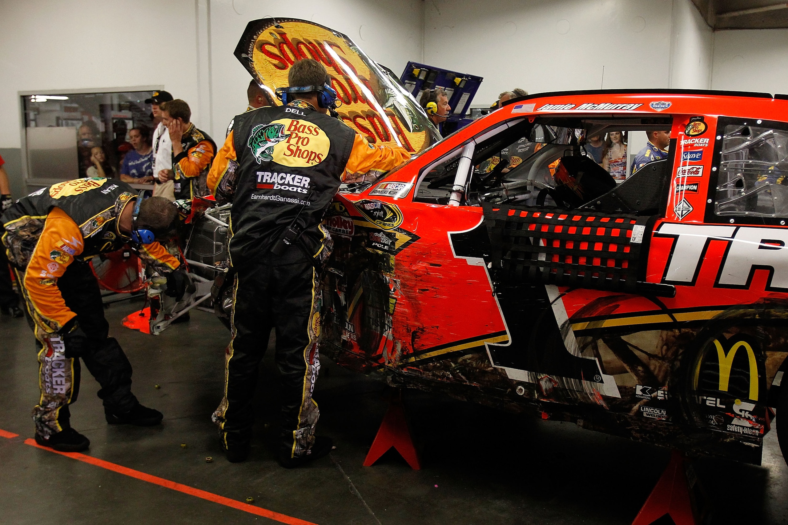 DAYTONA BEACH, FL - JULY 03:  Crew members work on the car of Jamie McMurray, driver of the #1 Bass Pro Shops/Tracker Chevrolet, after a crash during the NASCAR Sprint Cup Series Coke Zero 400 at Daytona International Speedway on July 3, 2010 in Daytona B
