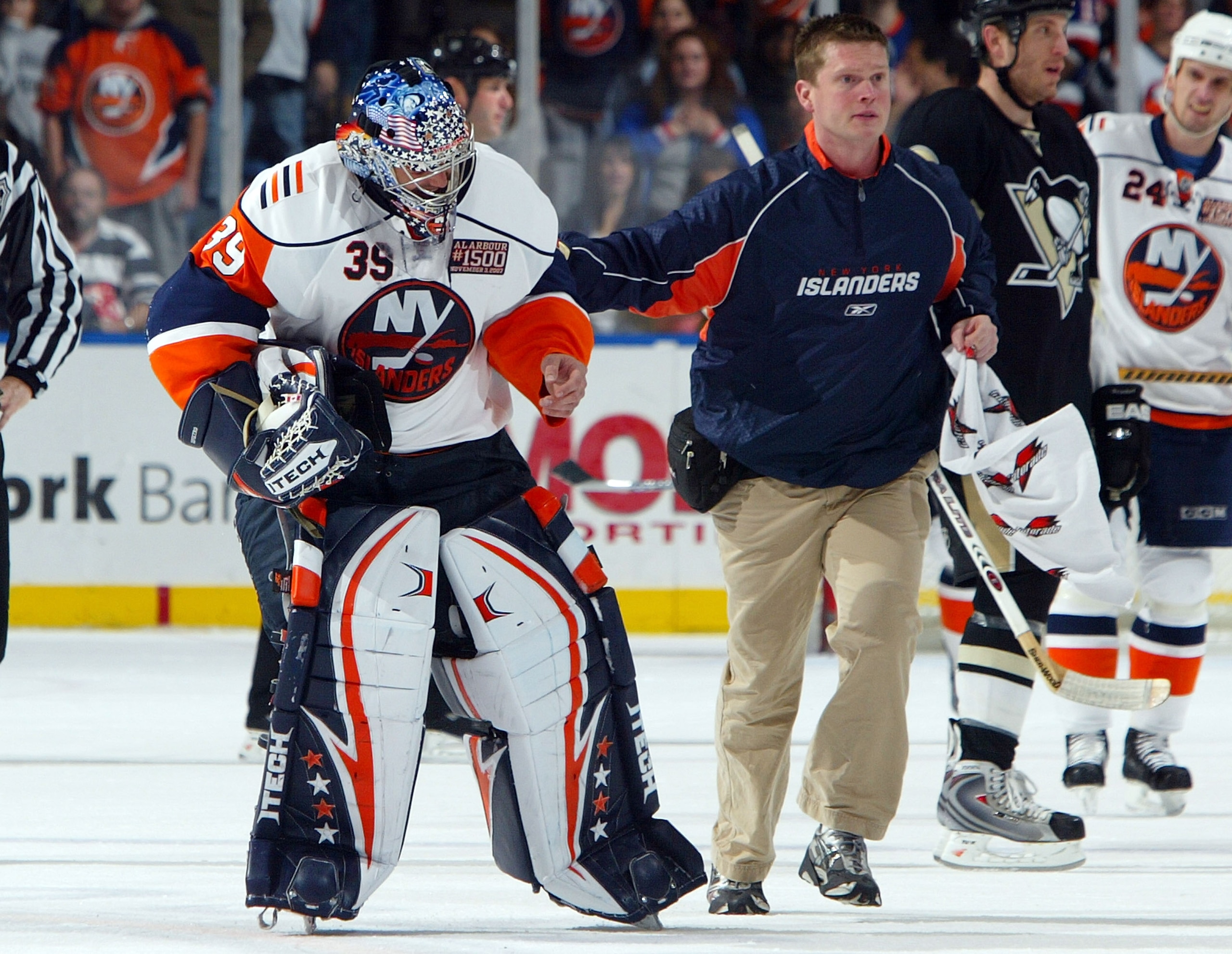 UNIONDALE, NY - NOVEMBER 03: Goaltender Rick DiPietro #39 of the New York Islanders is led off the ice by trainer Garrett Timms after suffering an eye injury against the Pittsburgh Penguins during their game on November 3, 2007 at Nassau Coliseum in Union