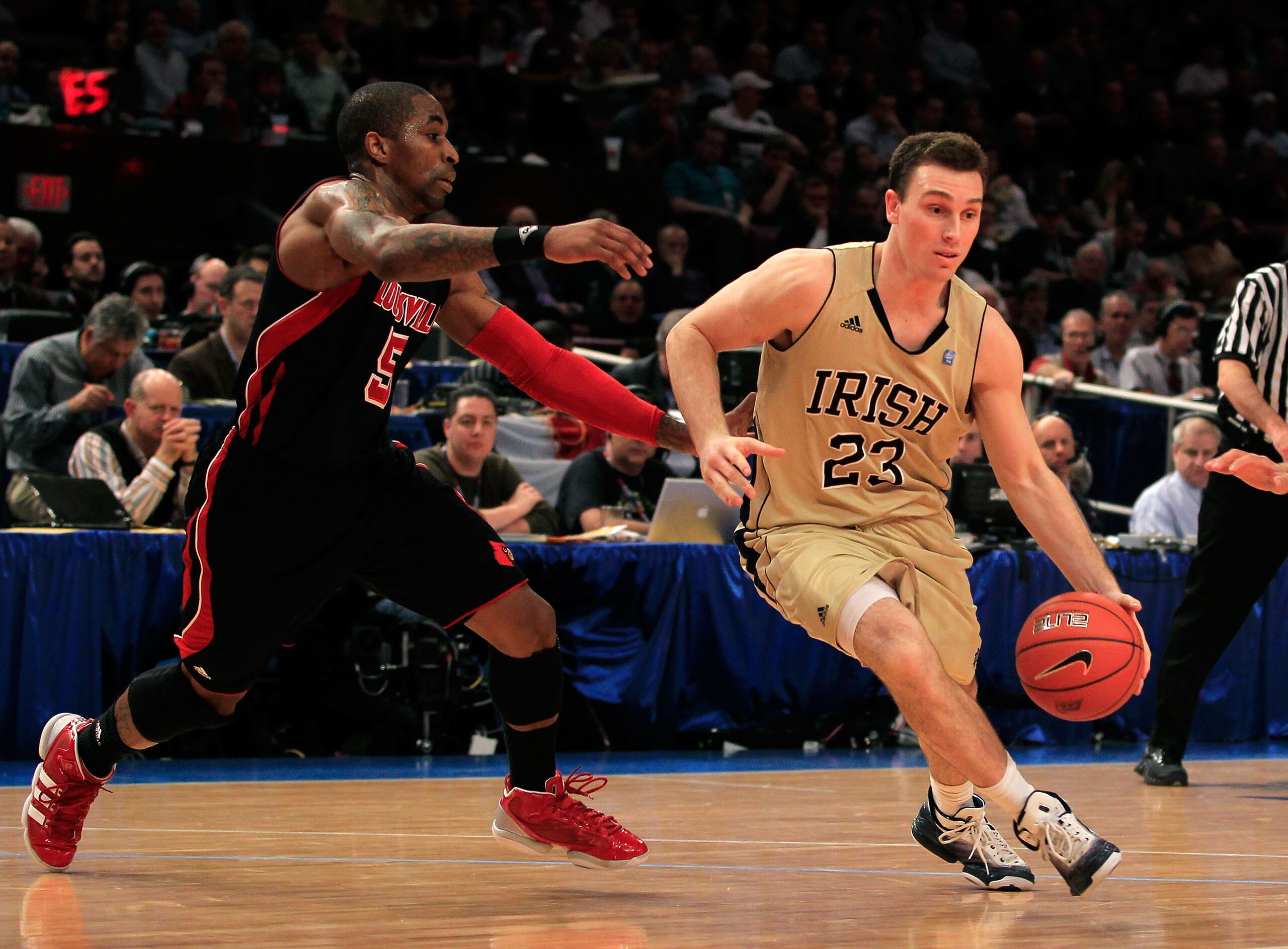 NEW YORK, NY - MARCH 11: Ben Hansbrough #23 of the Notre Dame Fighting Irish dribbles past Chris Smith #5 of the Louisville Cardinals during the semifinals of the 2011 Big East Men's Basketball Tournament presented by American Eagle Outfitters at Madison