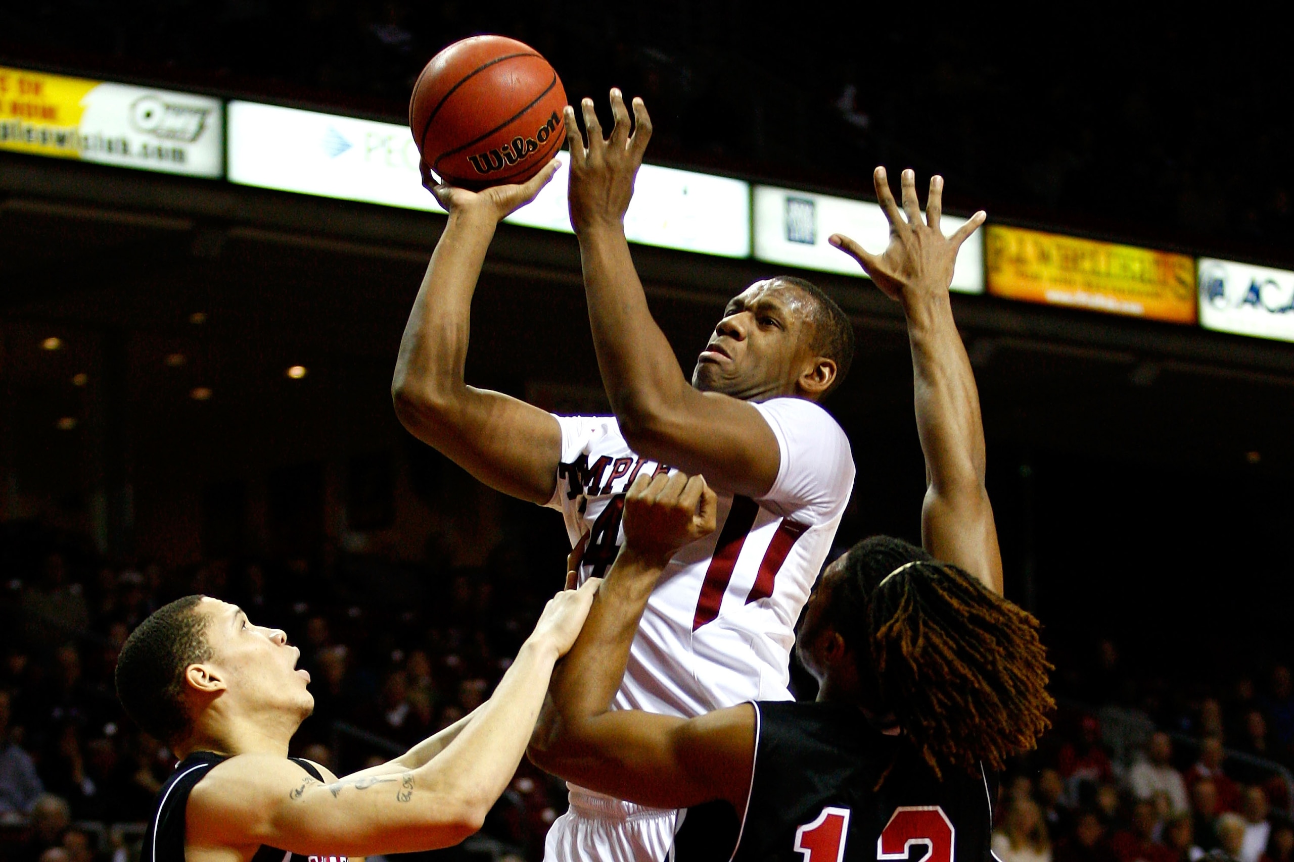 PHILADELPHIA, PA - DECEMBER 18:  Lavoy Allen #24 of the Temple Owls attempts a shot against Lee Fisher #30 (L) and Nate Rucker #12 of the Northern Illinois Huskies at the Liacouras Center on December 18, 2010 in Philadelphia, Pennsylvania.  (Photo by Chri