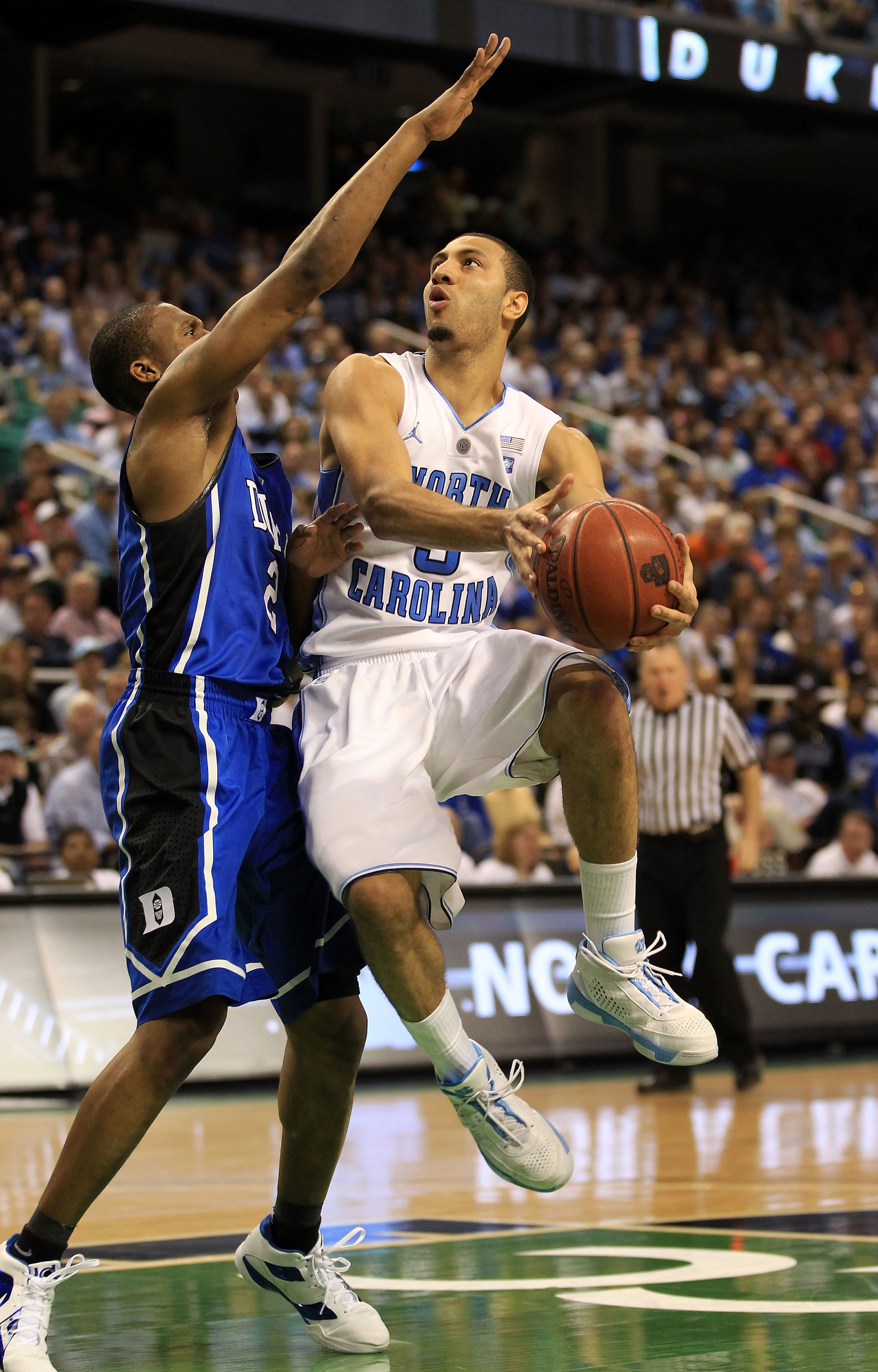 GREENSBORO, NC - MARCH 13:  Kendall Marshall #5 of the North Carolina Tar Heels shoots against Nolan Smith #2 of the Duke Blue Devils during the second half in the championship game of the 2011 ACC men's basketball tournament at the Greensboro Coliseum on
