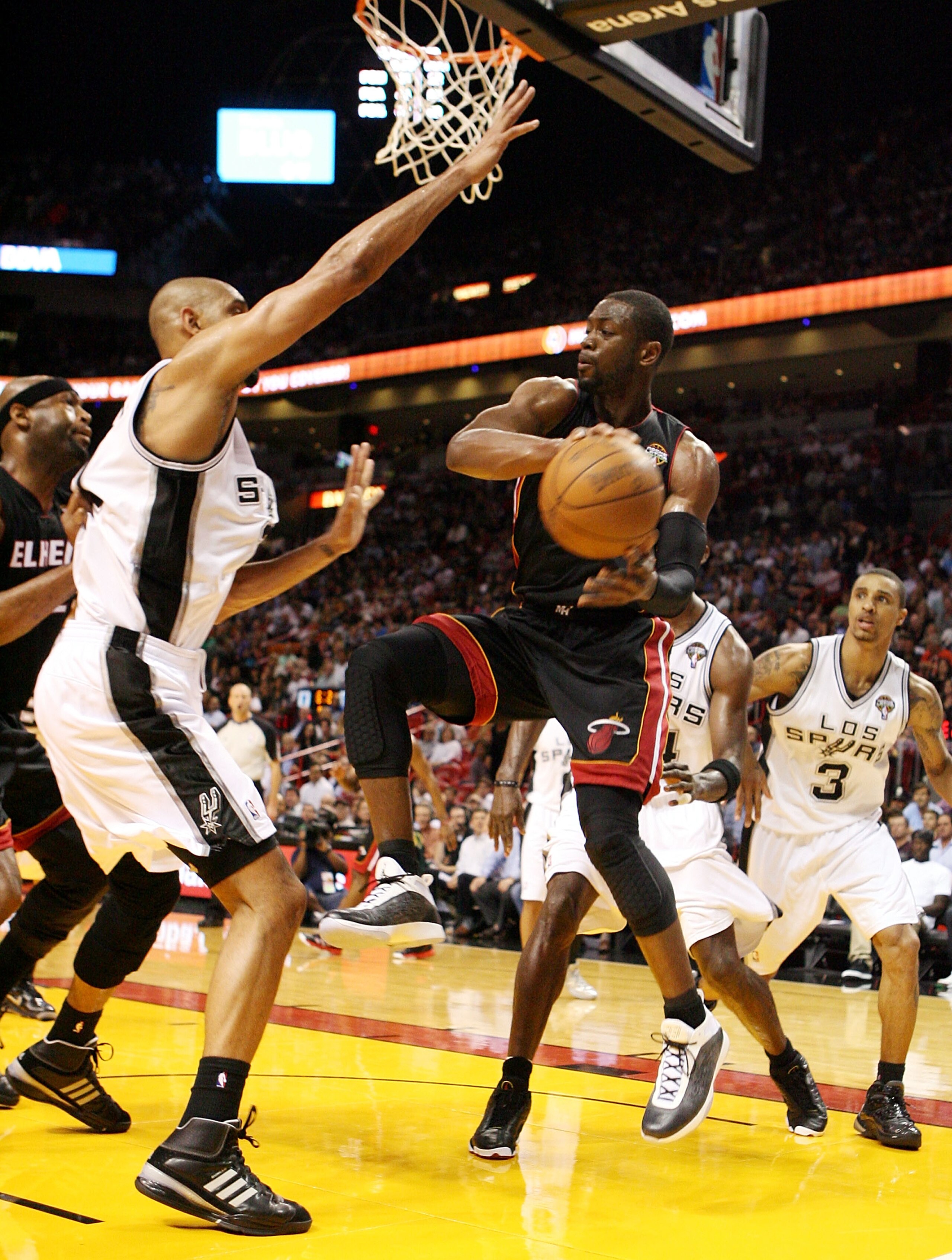 MIAMI - MARCH 14:  Guard Dwyane Wade #3 of the Miami Heat passes  against Center Tim Duncan #21 of the San Antonio Spurs at American Airlines Arena on March 14, 2011 in Miami, Florida. NOTE TO USER: User expressly acknowledges and agrees that, by download