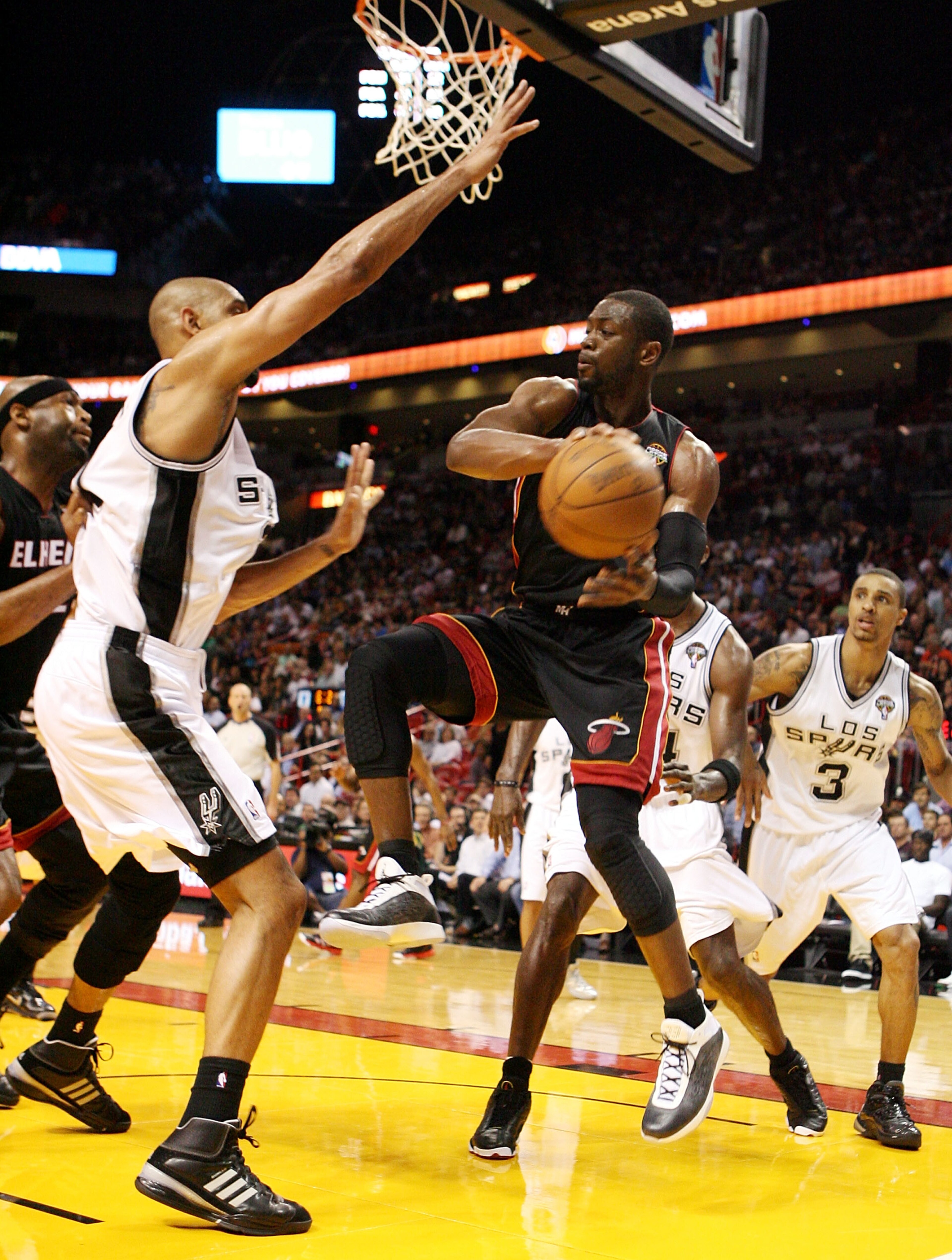 MIAMI - MARCH 14:  Guard Dwyane Wade #3 of the Miami Heat passes  against Center Tim Duncan #21 of the San Antonio Spurs at American Airlines Arena on March 14, 2011 in Miami, Florida. NOTE TO USER: User expressly acknowledges and agrees that, by download