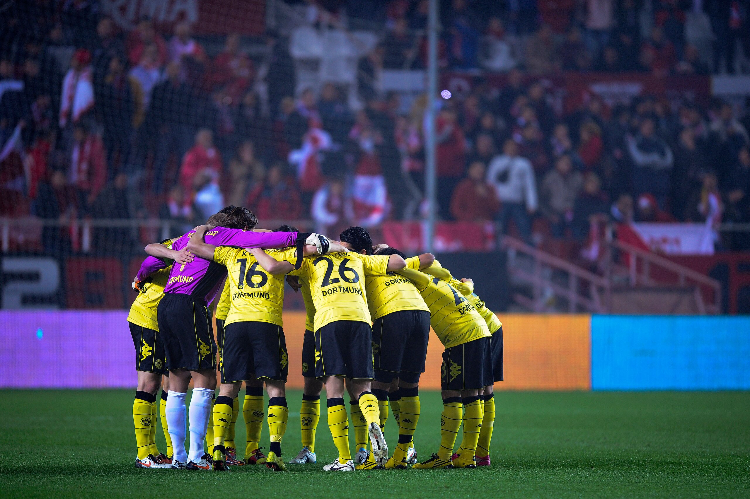 SEVILLE, SPAIN - DECEMBER 15:  Borussia Dortmund players hug themselves prior the UEFA Europa League group J match between Sevilla and Borussia Dortmund at Estadio Ramon Sanchez Pizjuan on December 15, 2010 in Seville, Spain. The match ended 2-2. (Photo b