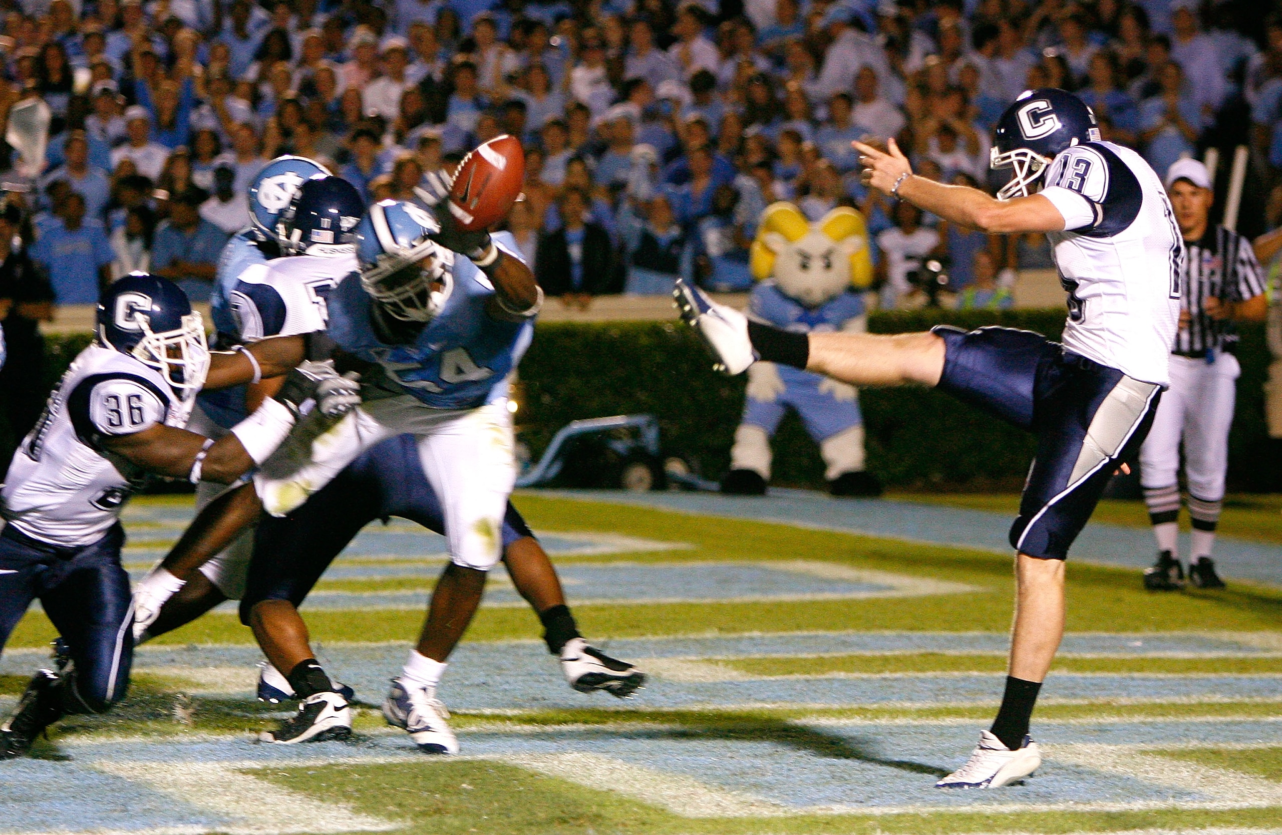 CHAPEL HILL, NC - OCTOBER 04:  Punter Desi Cullen #13 of the Connecticut Huskies has his punt blocked for a touchdown by Bruce Carter #54 of the North Carolina Tar Heels during the game at Kenan Stadium on October 4, 2008 in Chapel Hill, North Carolina.