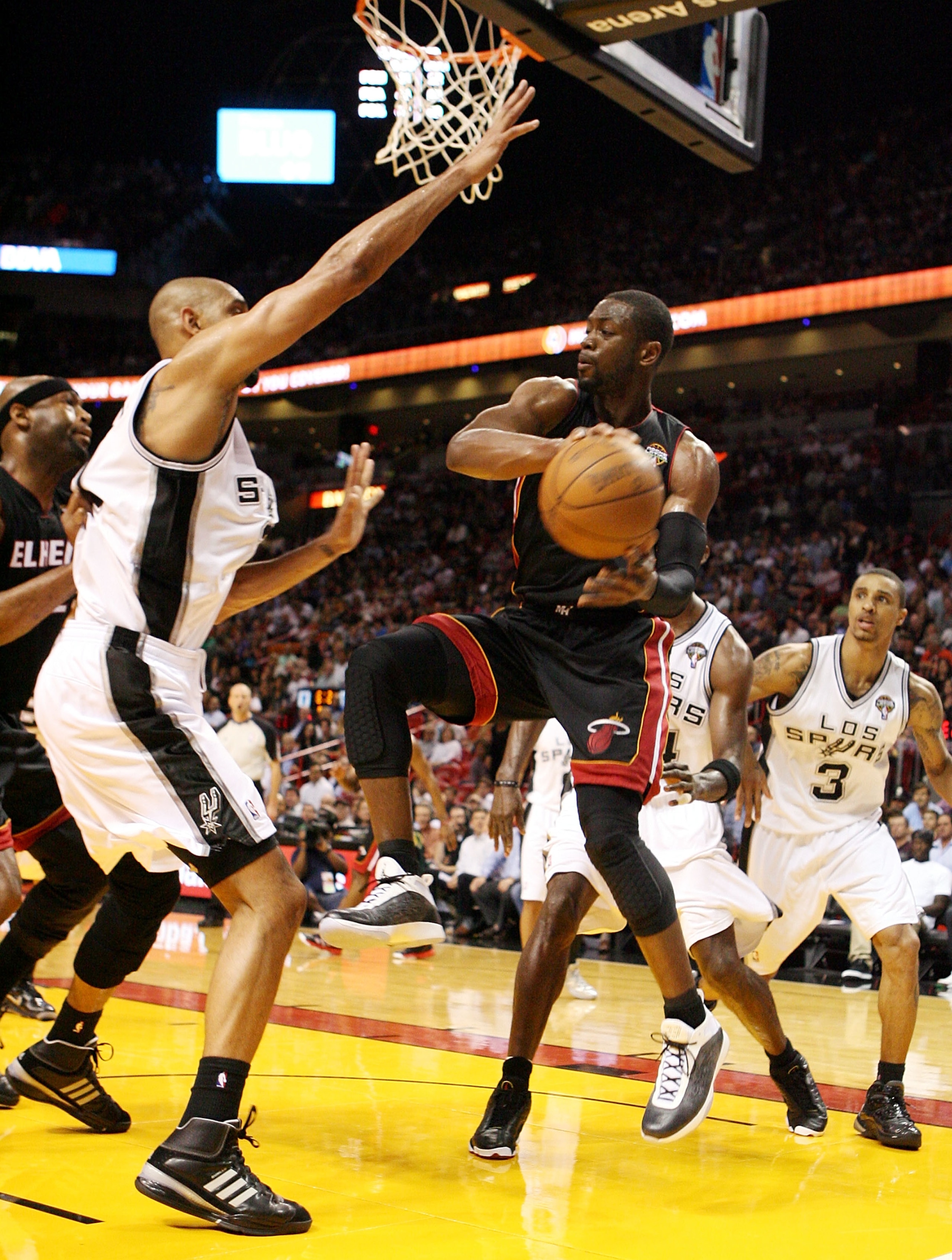 MIAMI - MARCH 14:  Guard Dwyane Wade #3 of the Miami Heat passes  against Center Tim Duncan #21 of the San Antonio Spurs at American Airlines Arena on March 14, 2011 in Miami, Florida. NOTE TO USER: User expressly acknowledges and agrees that, by download