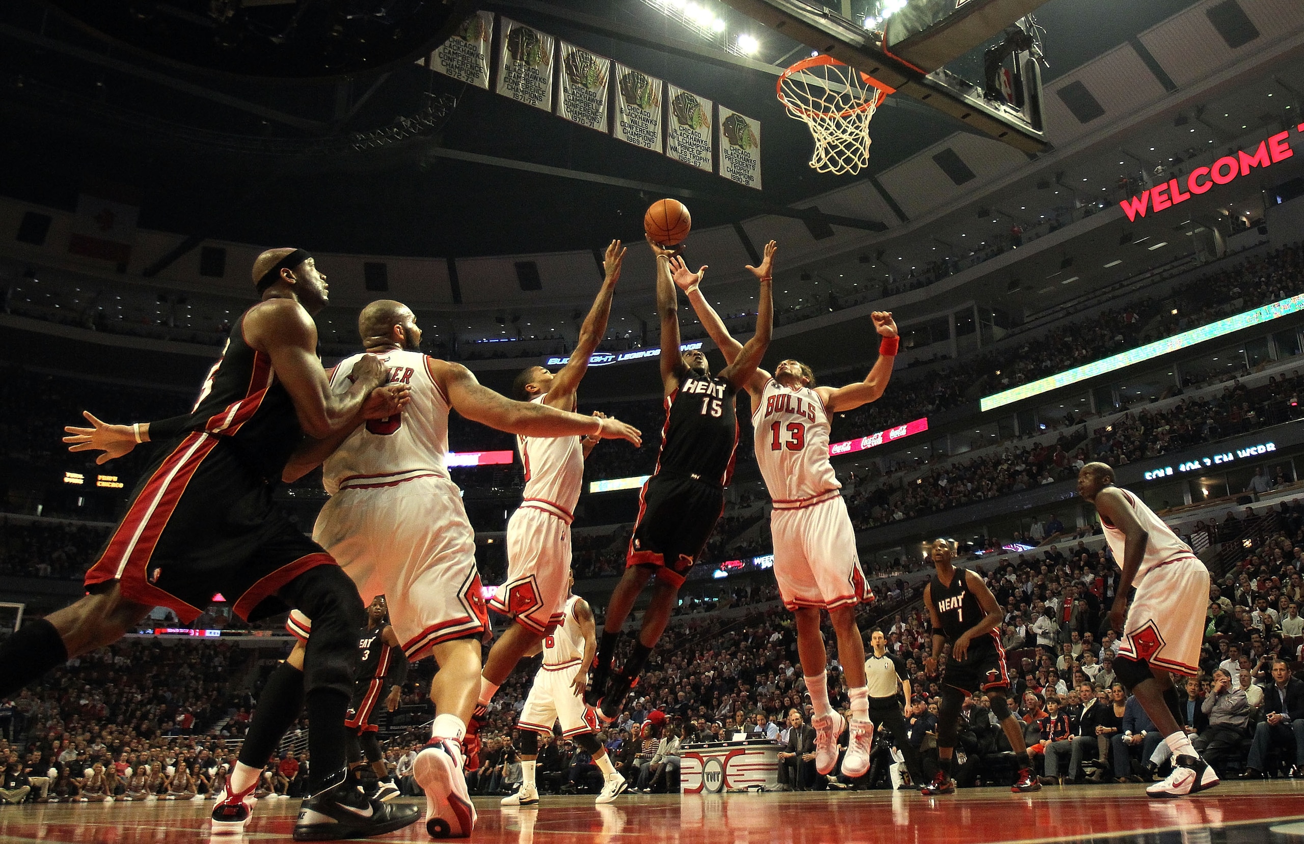 CHICAGO, IL - FEBRUARY 24: Mario Chalmers #15 of the Miami Heat puts up a shot between Derrick Rose #1 and Joakim Noah #13 of the Chicago Bulls at the United Center on February 24, 2011 in Chicago, Illinois. The Bulls defeated the Heat 93-89. NOTE TO USER