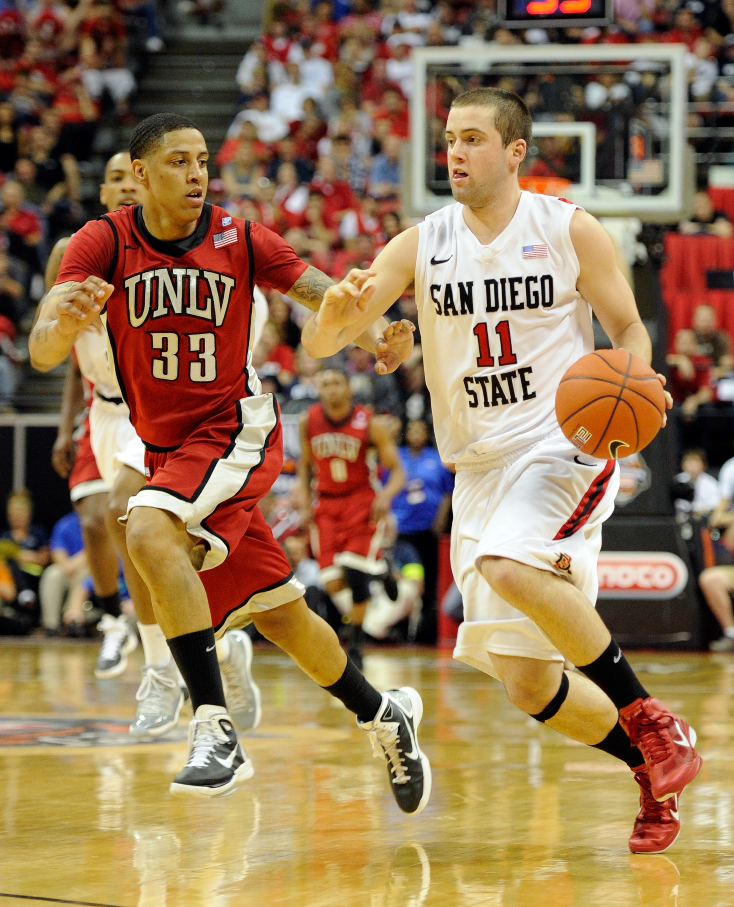 LAS VEGAS, NV - MARCH 11:  James Rahon #11 of the San Diego State Aztecs drives against Tre'Von Willis #33 of the UNLV Rebels during a semifinal game of the Conoco Mountain West Conference Basketball tournament at the Thomas & Mack Center March 11, 2011 i
