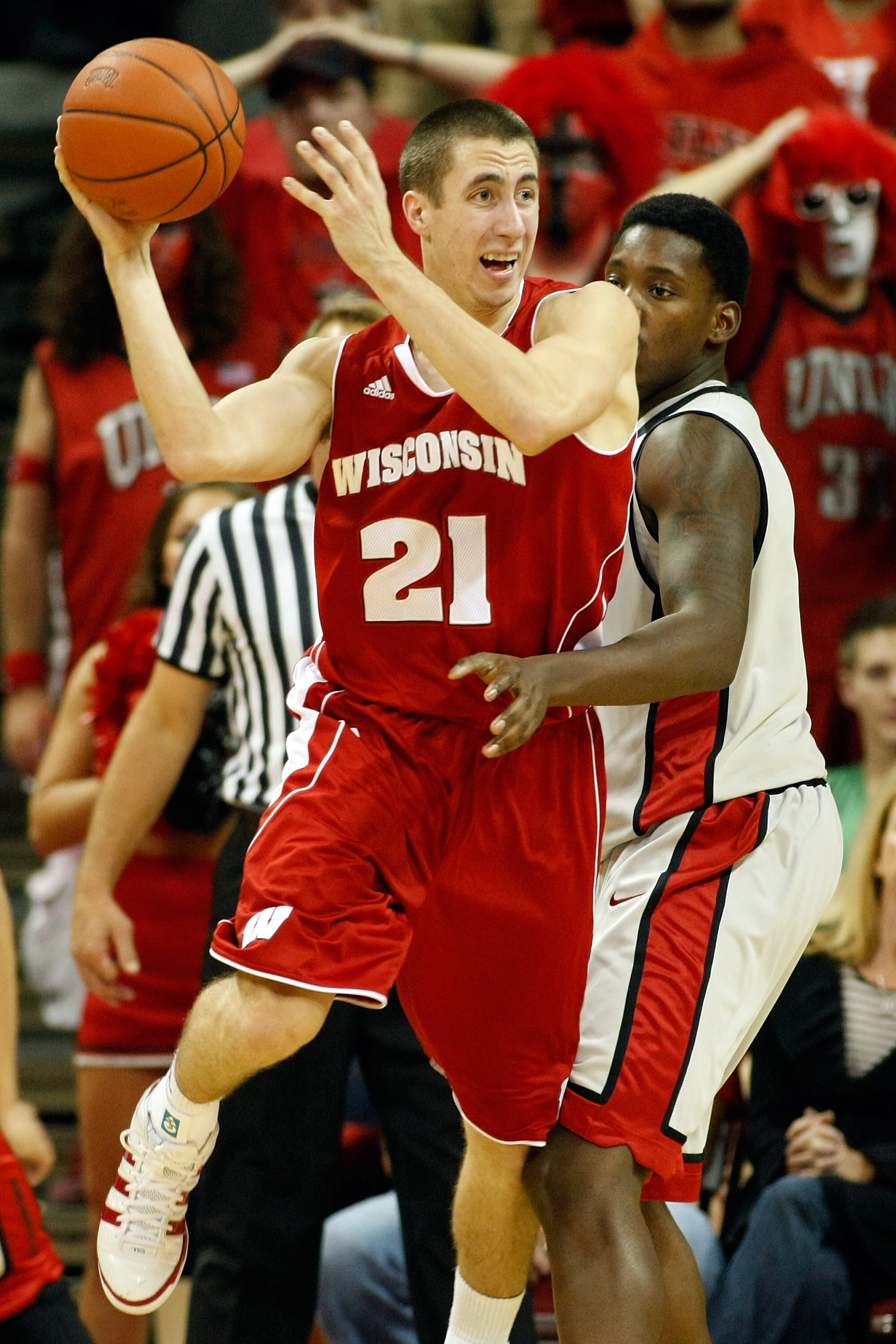 LAS VEGAS - NOVEMBER 20:  Josh Gasser #21 of the Wisconsin Badgers looks to pass as Quintrell Thomas #1 of the UNLV Rebels defends during their game at the Thomas & Mack Center November 20, 2010 in Las Vegas, Nevada. UNLV won 68-65.  (Photo by Ethan Mille