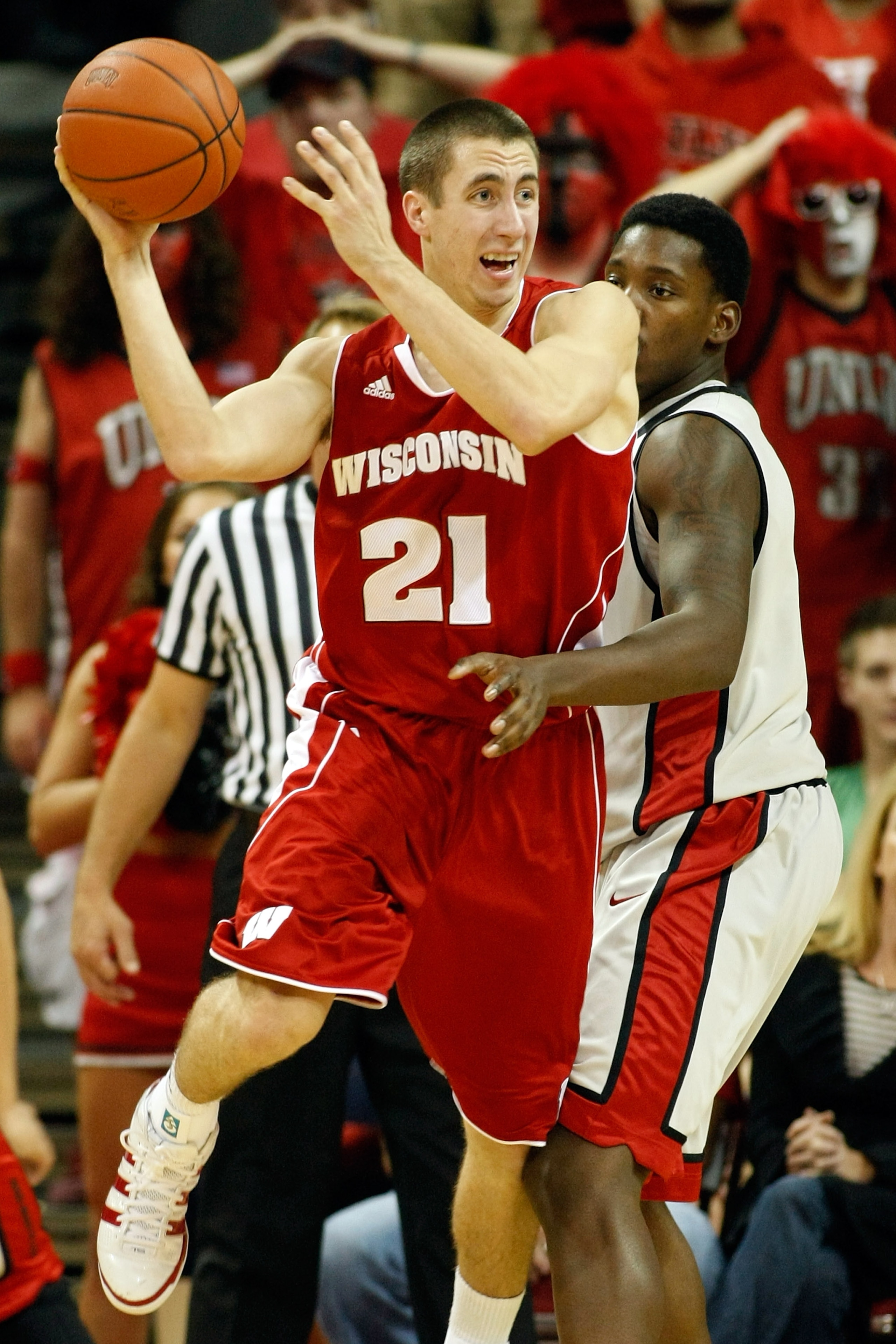 LAS VEGAS - NOVEMBER 20:  Josh Gasser #21 of the Wisconsin Badgers looks to pass as Quintrell Thomas #1 of the UNLV Rebels defends during their game at the Thomas & Mack Center November 20, 2010 in Las Vegas, Nevada. UNLV won 68-65.  (Photo by Ethan Mille