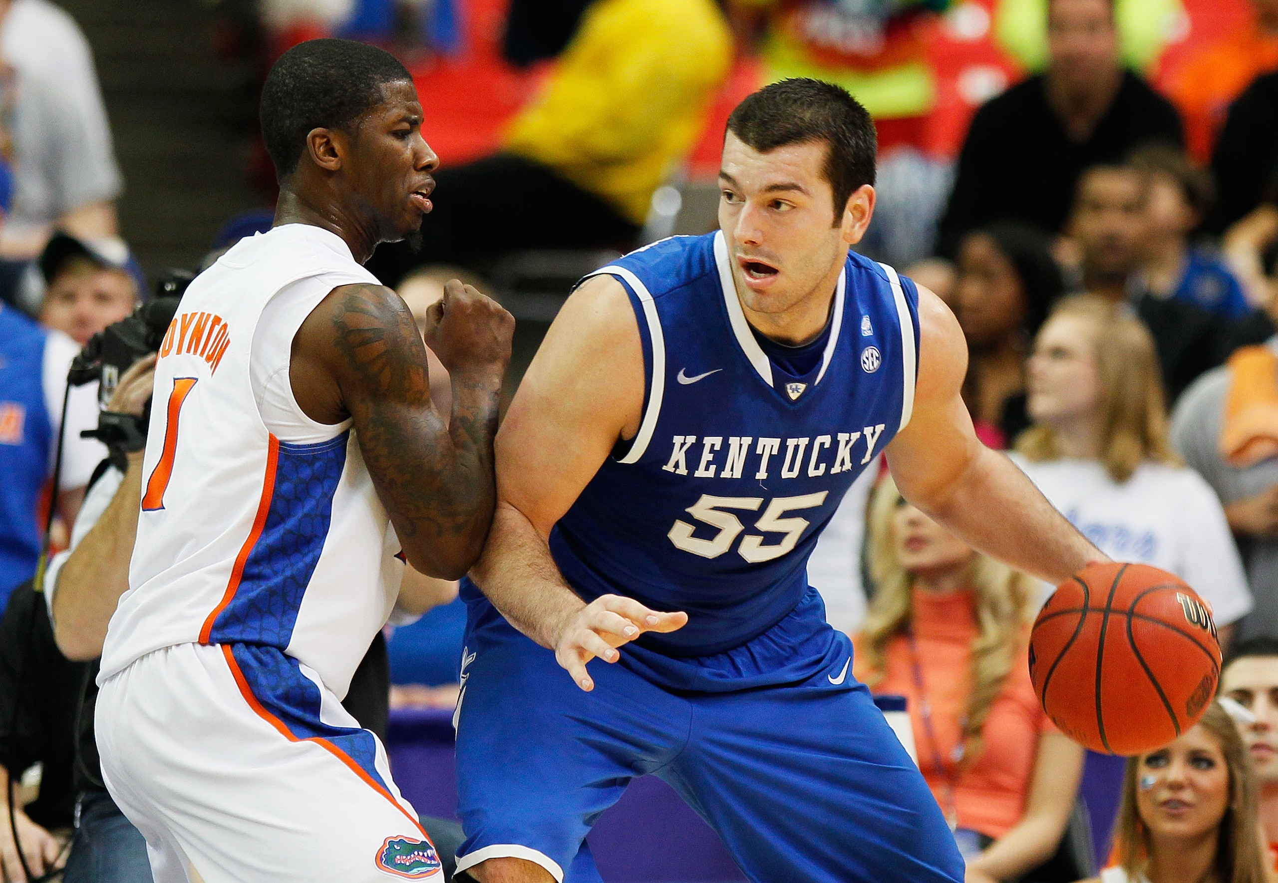 ATLANTA, GA - MARCH 13:  Josh Harrellson #55 of the Kentucky Wildcats drives against Kenny Boynton #1 of the Florida Gators during the championship game of the SEC Men's Basketball Tournament at Georgia Dome on March 13, 2011 in Atlanta, Georgia.  (Photo