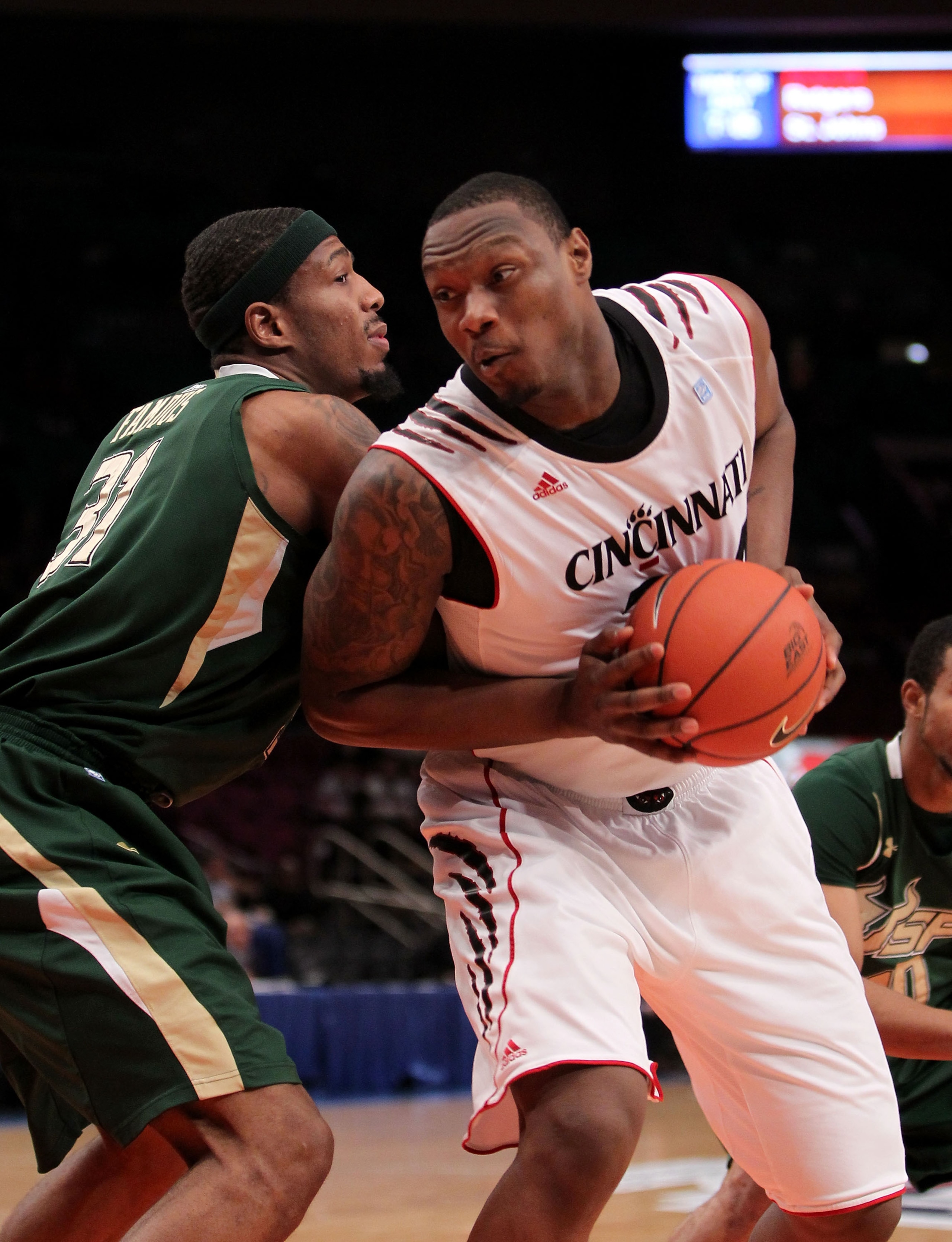NEW YORK, NY - MARCH 09: Yancy Gates #34 of the Cincinnati Bearcats battles for position against Jarrid Famous #31 of the South Florida Bulls during the second round of the 2011 Big East Men's Basketball Tournament presented by American Eagle Outfitters a