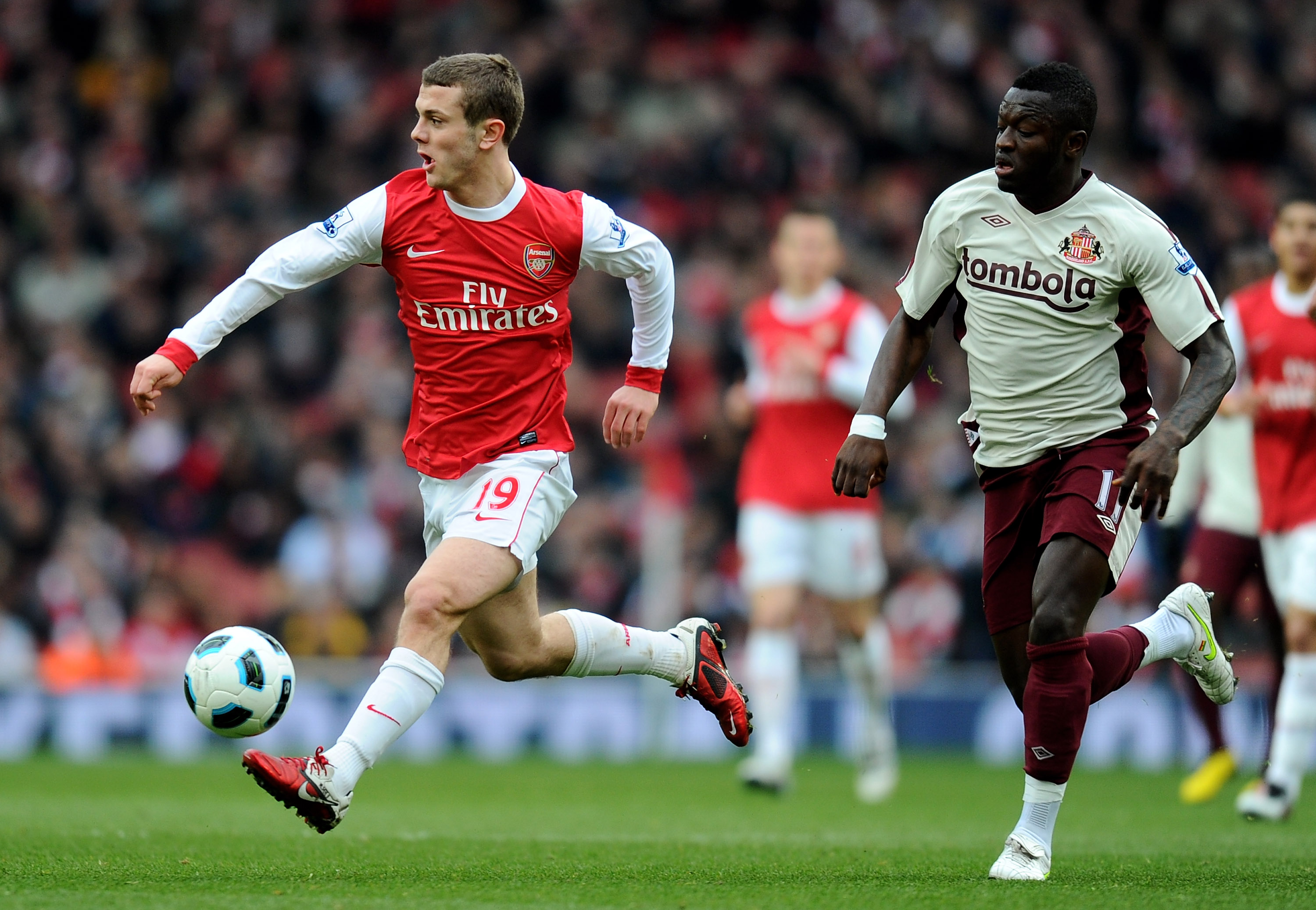 LONDON, ENGLAND - MARCH 05:   Jack Wilshere of Arsenal is pursued by Sulley Muntari of Sunderland during the Barclays Premier League match between Arsenal and Sunderland at Emirates Stadium on March 5, 2011 in London, England.  (Photo by Mike Hewitt/Getty