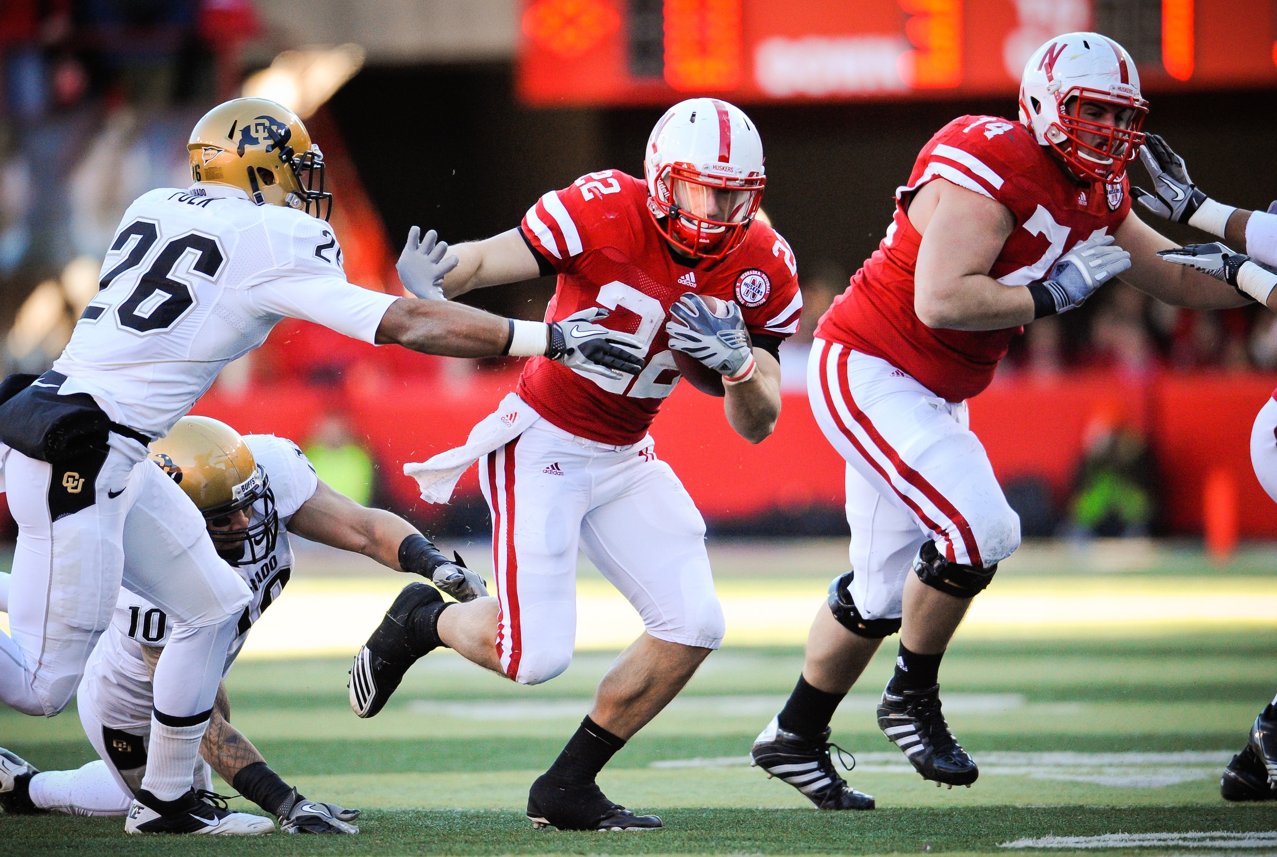 LINCOLN, NE - NOVEMBER 26: Rex Burkhead #22 of the Nebraska Cornhuskers slips past Ray Polk #26 of the Colorado Buffaloes during their game at Memorial Stadium on November 26, 2010 in Lincoln, Nebraska. Nebraska defeated Colorado 45-17 (Photo by Eric Fran