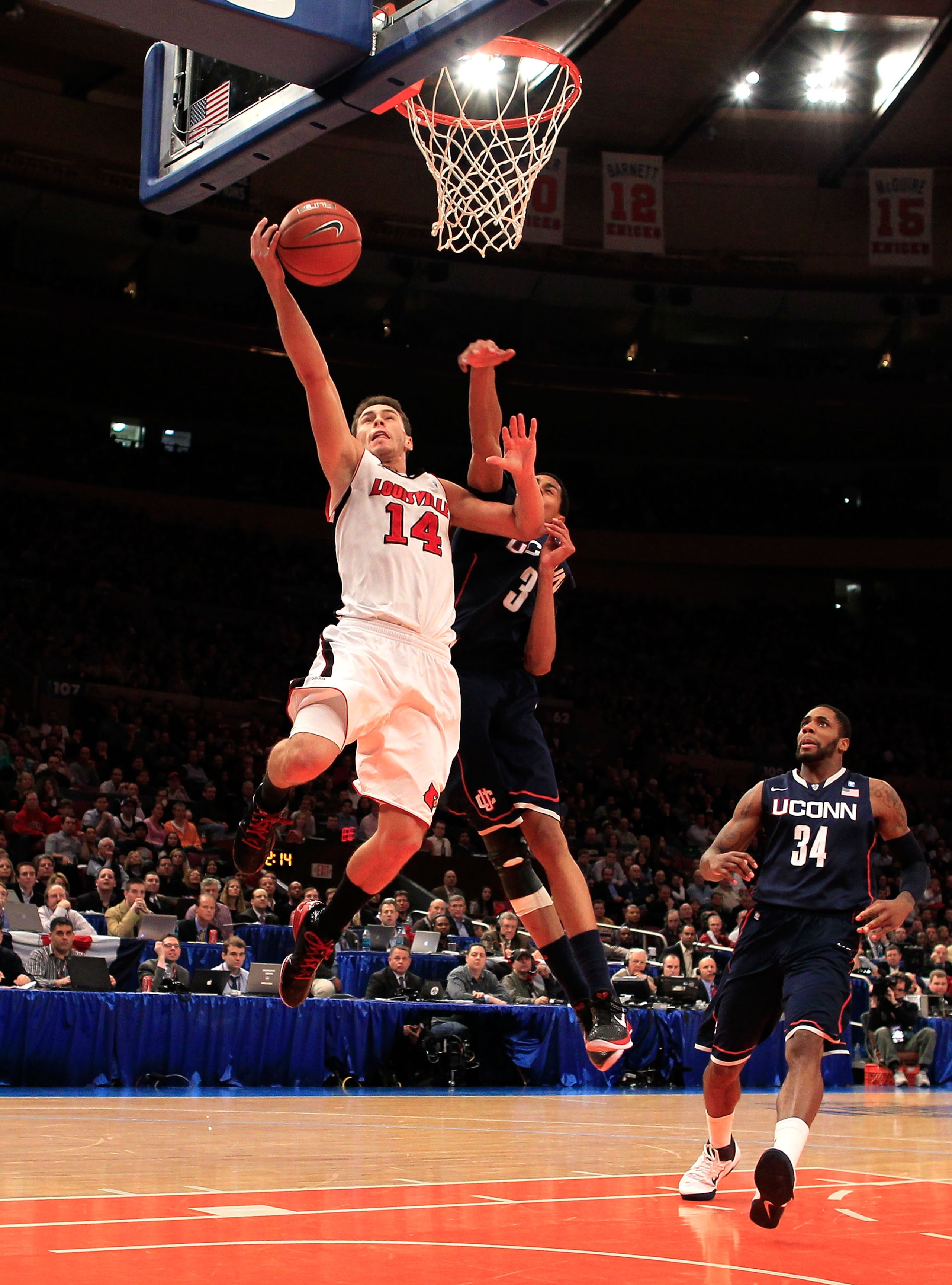 NEW YORK, NY - MARCH 12: Kyle Kuric #14 of the Louisville Cardinals drives to the basket against Jeremy Lamb #3 of the Connecticut Huskies during the championship of the 2011 Big East Men's Basketball Tournament presented by American Eagle Outfitters at M
