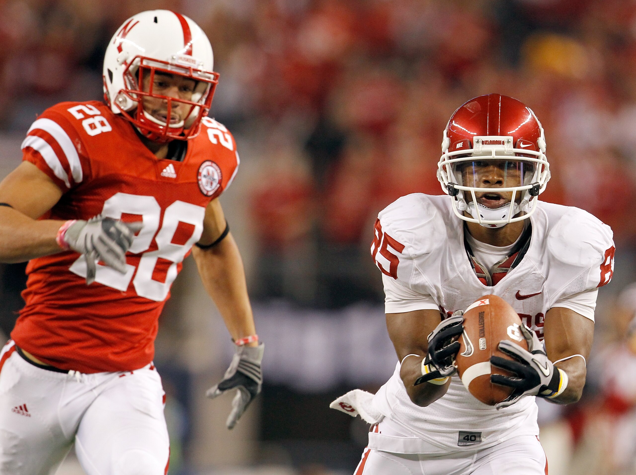 ARLINGTON, TX - DECEMBER 04:  Wide receiver Ryan Broyles #85 of the Oklahoma Sooners pulls in a pass against defensive back Eric Hagg #28 of the Nebraska Cornhuskers at Cowboys Stadium on December 4, 2010 in Arlington, Texas.  The Sooners beat the Cornhus