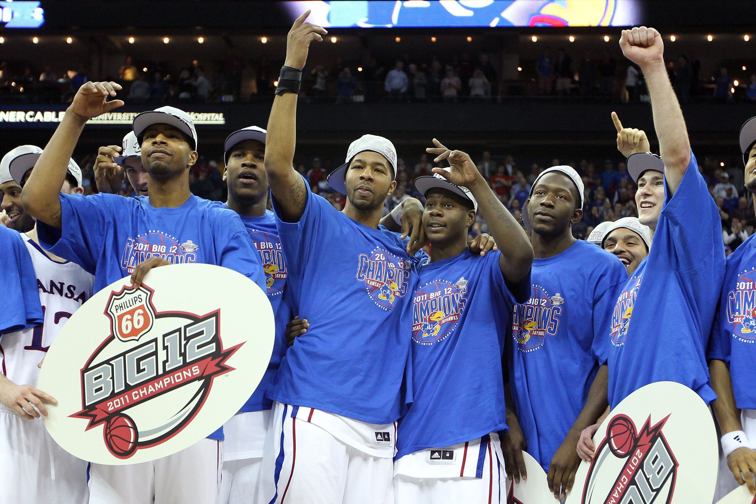 KANSAS CITY, MO - MARCH 12: (3rd from L and 3rd from R)) Markieff Morris #21 and Josh Selby #32 of the Kansas Jayhawks of the Kansas Jayhawks celebrate with their teammates after defeating the Texas Longhorns 85-73 to win the 2011 Phillips 66 Big 12 Men's