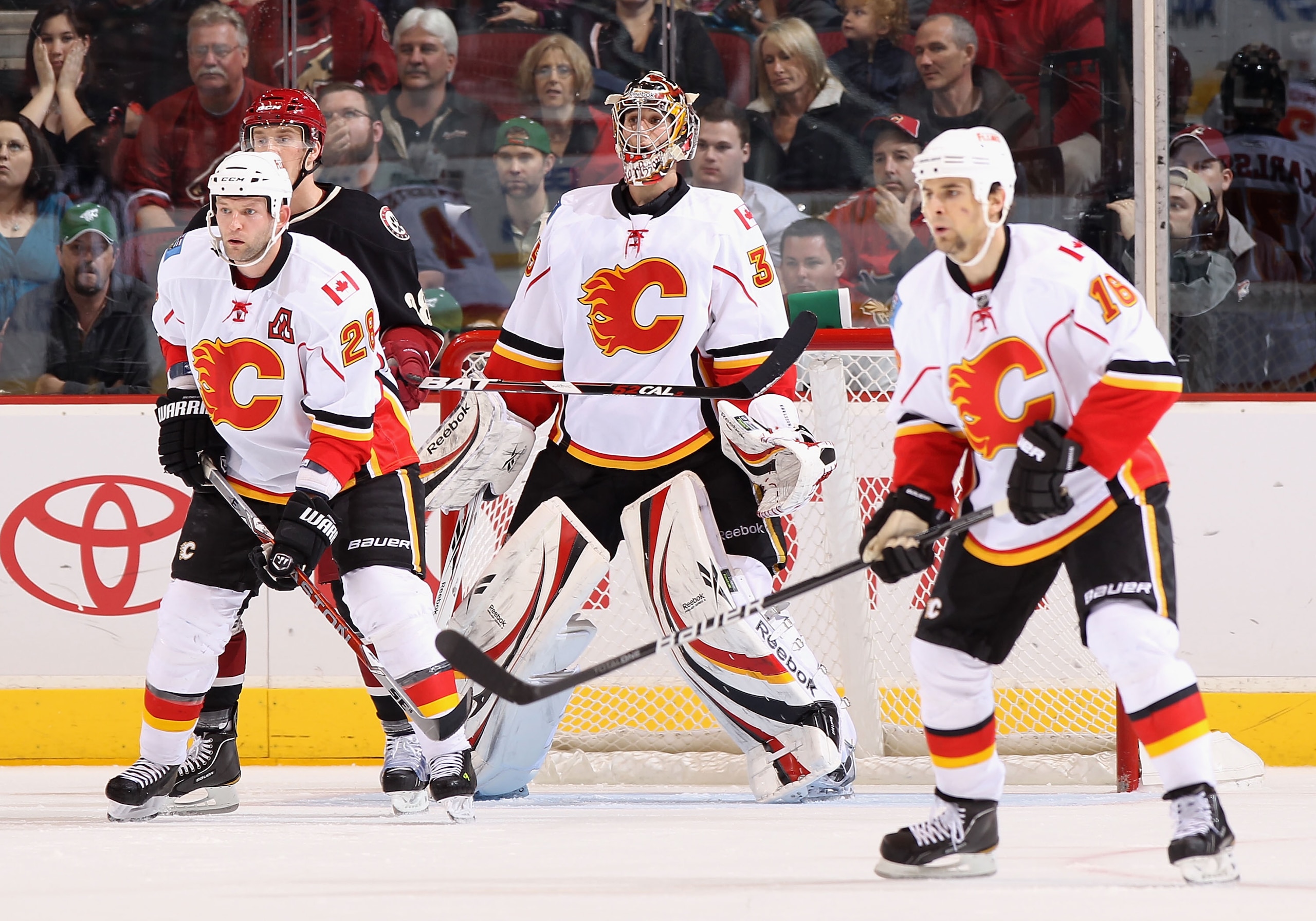 GLENDALE, AZ - MARCH 10:  (L-R) Robyn Regehr #28, goaltender Henrik Karlsson #35 and Tom Kostopoulos #16 of the Calgary Flames in action during the NHL game against the Phoenix Coyotes at Jobing.com Arena on March 10, 2011 in Glendale, Arizona.  The Coyot