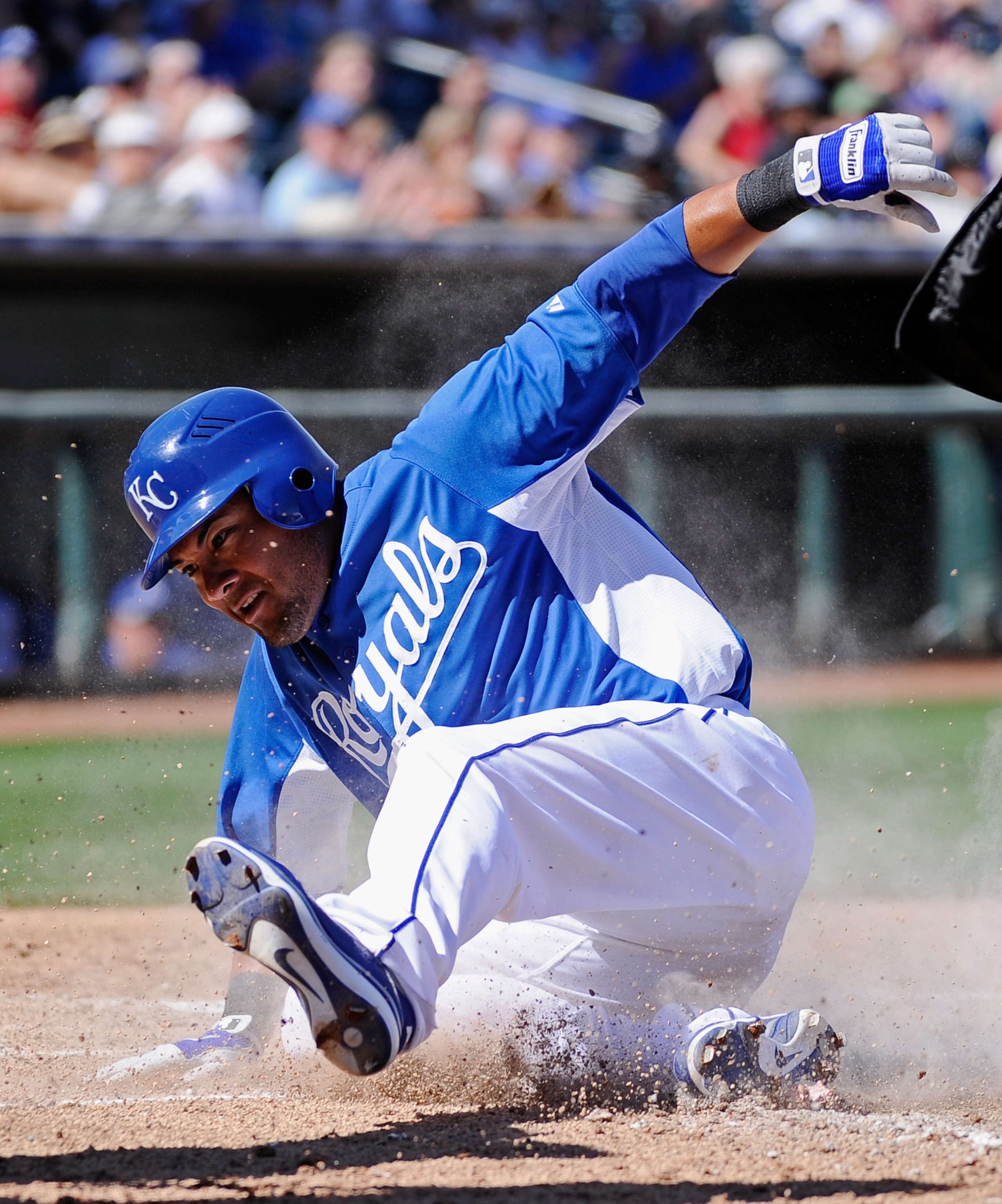 SURPRISE, AZ - MARCH 12:  Melky Cabrera #53 of the Kansas City Royals slides at home plate to score a run during the fourth inning of the spring training baseball game against the Los Angeles Dodgers at Surprise Stadium on March 12, 2011 in Surprise, Ariz