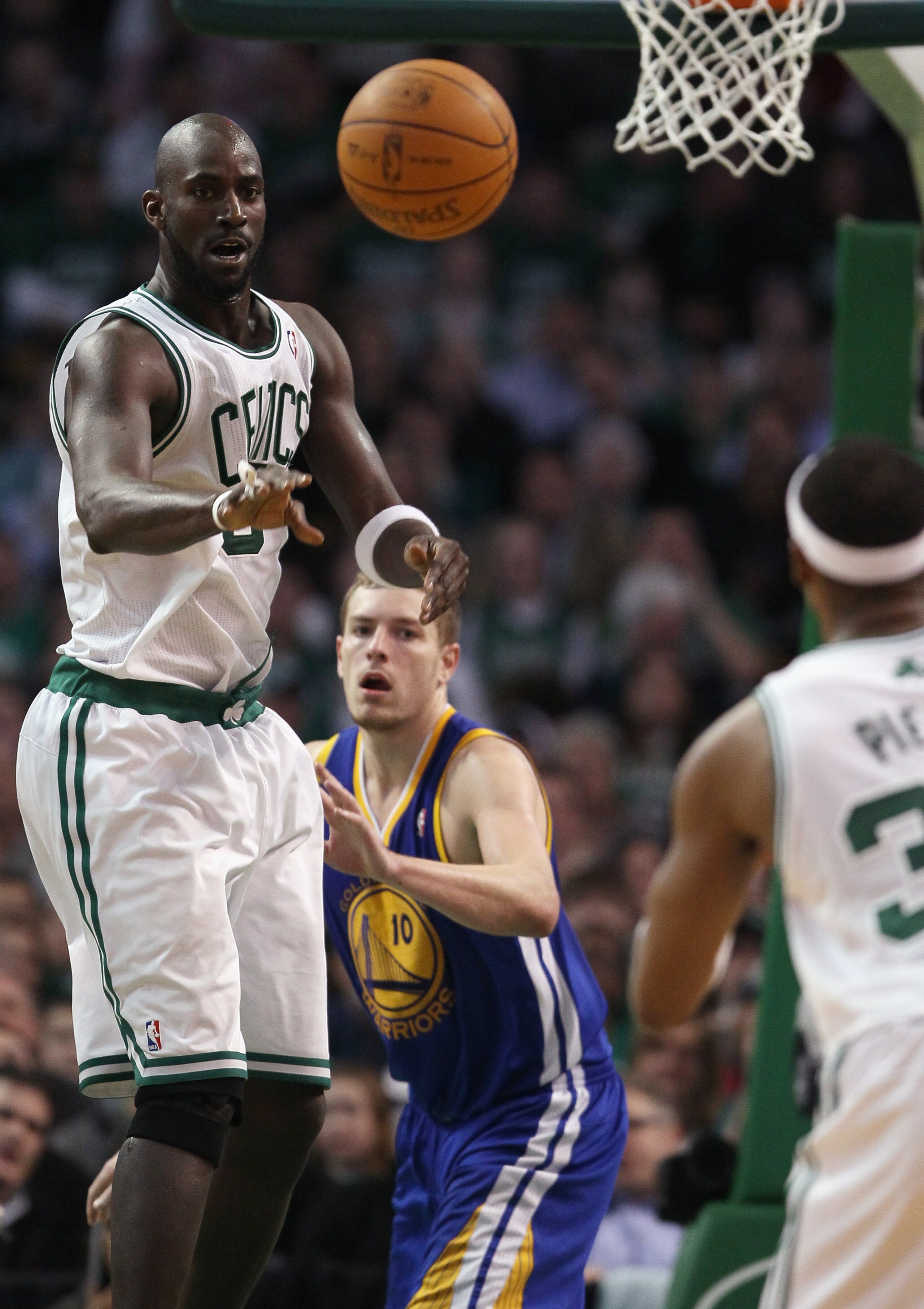 BOSTON, MA - MARCH 04: Kevin Garnett #5 of the Boston Celtics passes the ball to Paul Pierce #34 as David Lee #10 of the Golden State Warriors defends on March 4, 2011 at the TD Garden in Boston, Massachusetts.  The Celtics defeated the Warriors 107-103.