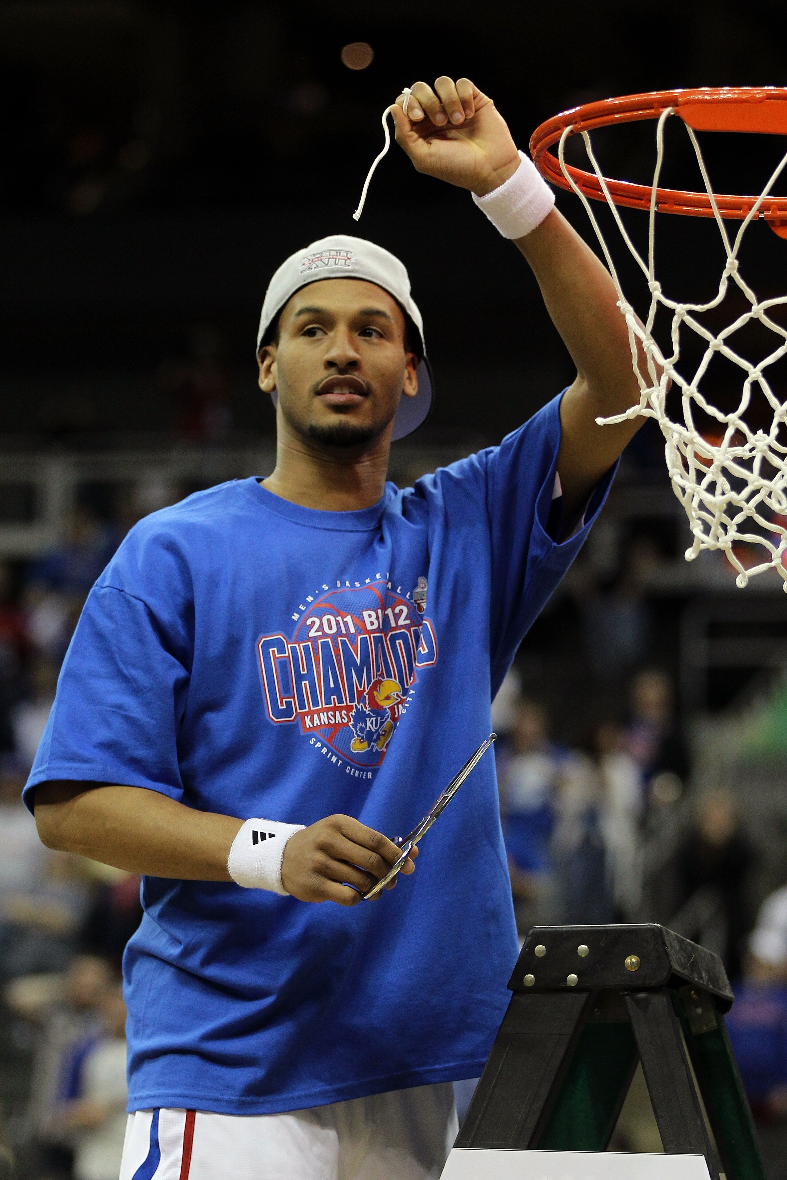 KANSAS CITY, MO - MARCH 12:  Travis Releford #24 of the Kansas Jayhawks celebrates by cutting down the net after defeating the Texas Longhorns 85-73 to win the 2011 Phillips 66 Big 12 Men's Basketball Tournament championship game at Sprint Center on March