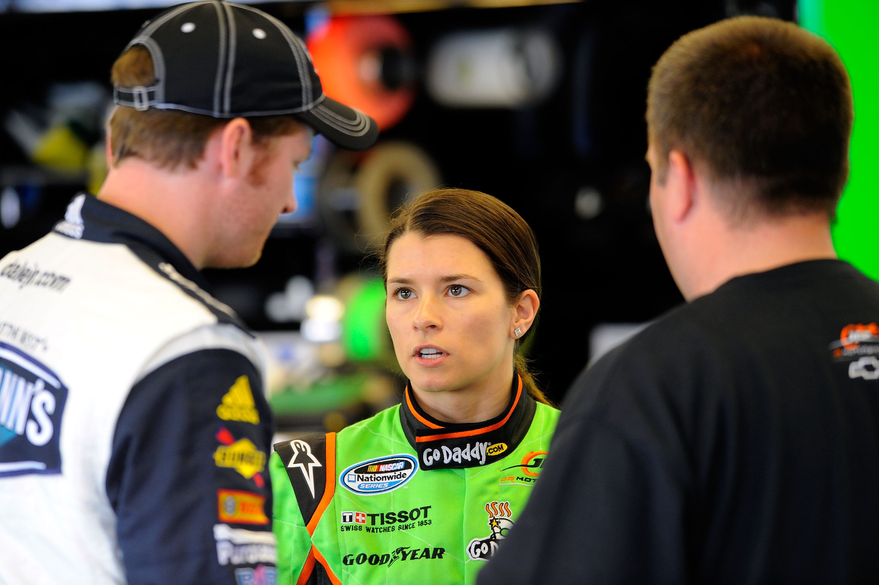 DAYTONA BEACH, FL - FEBRUARY 17:  Danica Patrick (C), driver of the #7 GoDaddy.com Chevrolet, talks with Dale Earnhardt Jr. (L), driver of the #5 Hellmann's Chevrolet, and crew chief Tony Eury Jr. (R) in the garage during practice for the NASCAR Nationwid