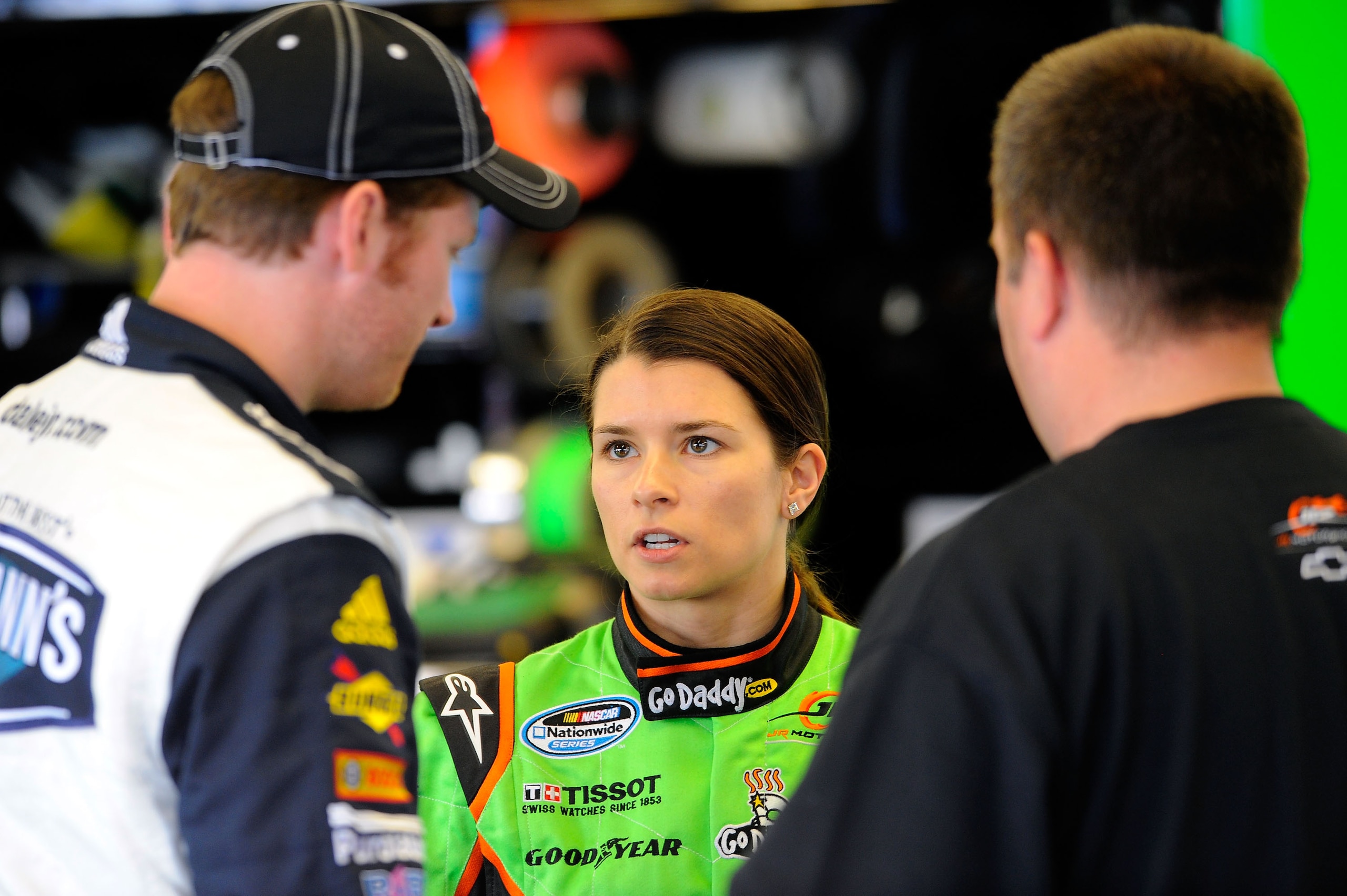 DAYTONA BEACH, FL - FEBRUARY 17:  Danica Patrick (C), driver of the #7 GoDaddy.com Chevrolet, talks with Dale Earnhardt Jr. (L), driver of the #5 Hellmann's Chevrolet, and crew chief Tony Eury Jr. (R) in the garage during practice for the NASCAR Nationwid