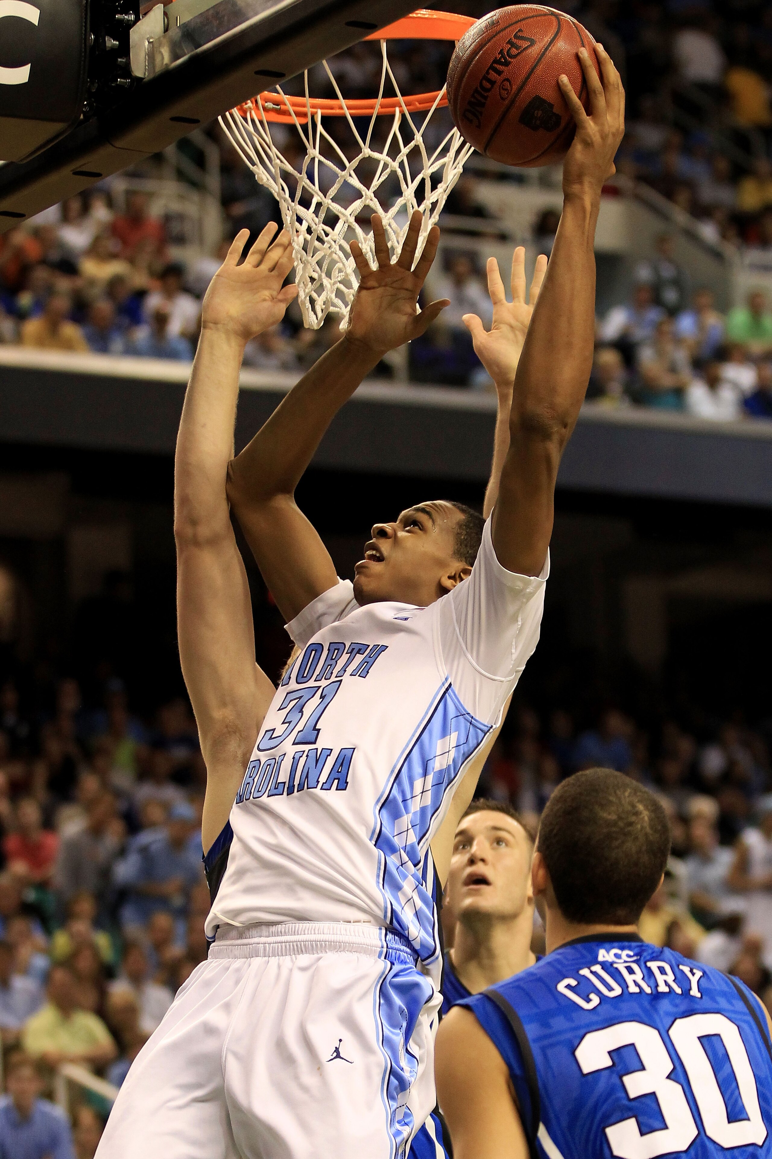 GREENSBORO, NC - MARCH 13:  John Henson #31 of the North Carolina Tar Heels shoots against Seth Curry #30 of the Duke Blue Devils during the second half in the championship game of the 2011 ACC men's basketball tournament at the Greensboro Coliseum on Mar