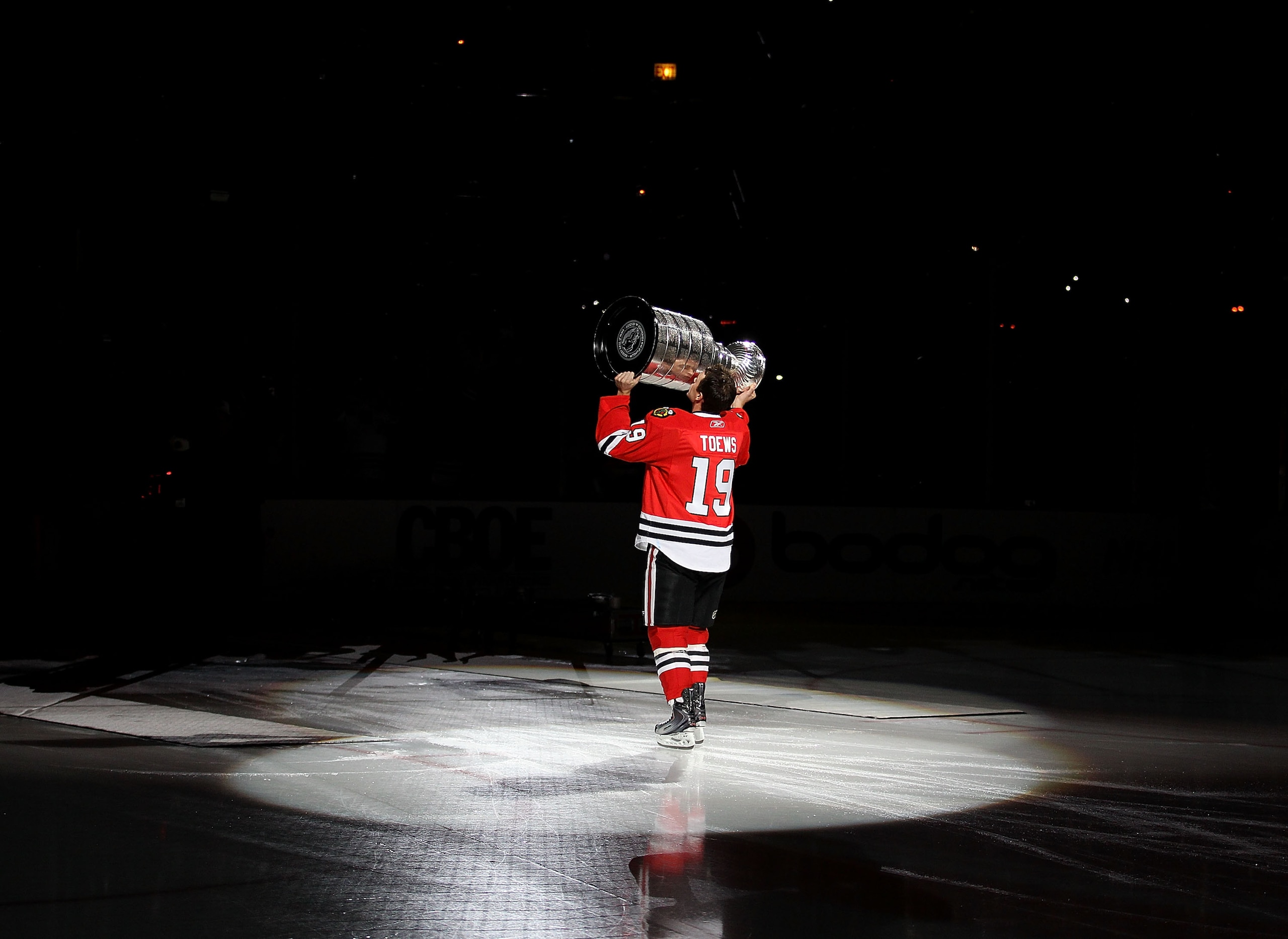 CHICAGO - OCTOBER 09: Jonathan Toews #19 of the Chicago Blackhawks kisses the Stanley Cup trophy as he skates across the ice in a ceremony before the Blackhawks season home opening game against the Detroit Red Wings at the United Center on October 9, 2010