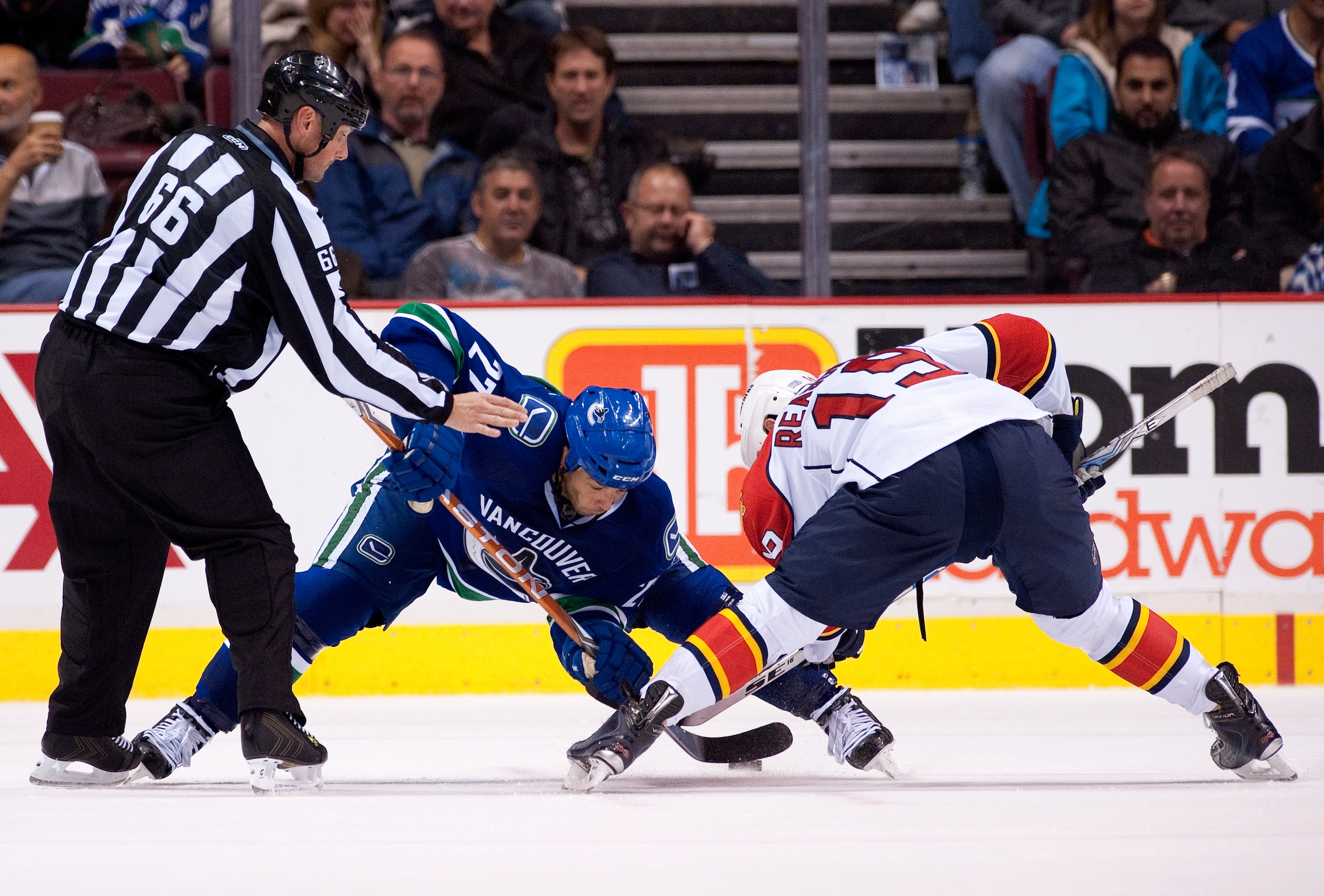 VANCOUVER, CANADA - OCTOBER 11: Manny Malhotra #27 of the Vancouver Canucks wins a face-off against Marty Reasoner #19 of the Florida Panthers during the second period in NHL action on October 11, 2010 at Rogers Arena in Vancouver, British Columbia, Canad
