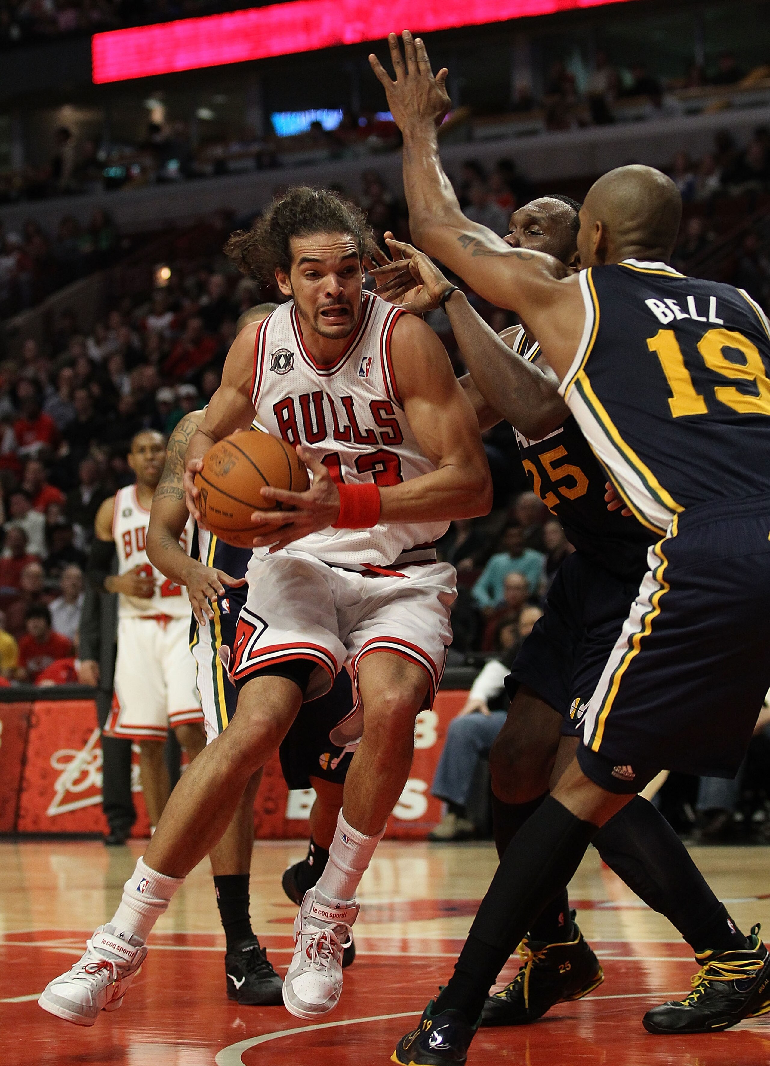 CHICAGO, IL - MARCH 12: Joakim Noah #13 of the Chicago Bulls drives against Al Jefferson #25 and Raja Bell #19 of the Utah Jazz at the United Center on March 12, 2011 in Chicago, Illinois. The Bulls defeated the Jazz 118-100. NOTE TO USER: User expressly
