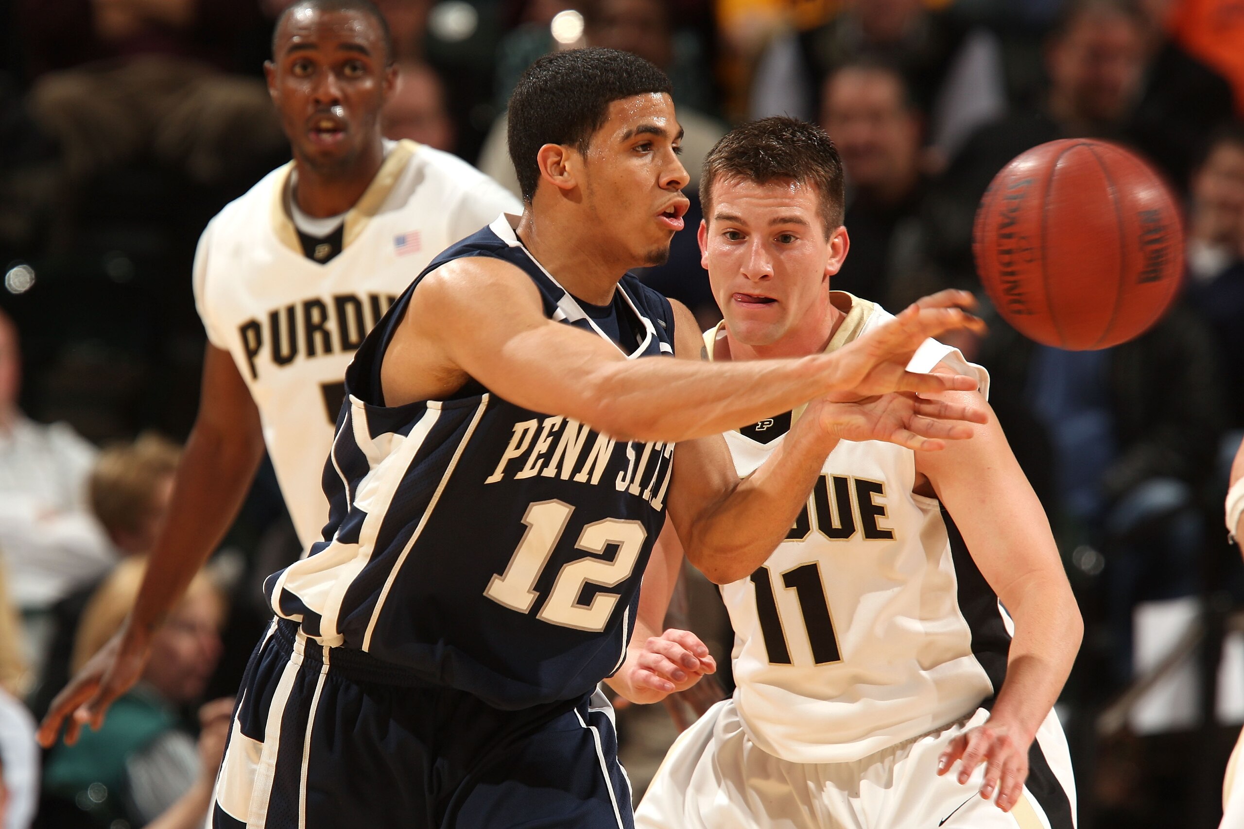 INDIANAPOLIS - MARCH 13:  Talor Battle #12 of the Penn State Nittany Lions passes the ball against Bobby Riddell #11 of the Purdue Boilermakers during the second round of the Big Ten Men's Basketball Tournament at Conseco Fieldhouse on March 13, 2009 in I