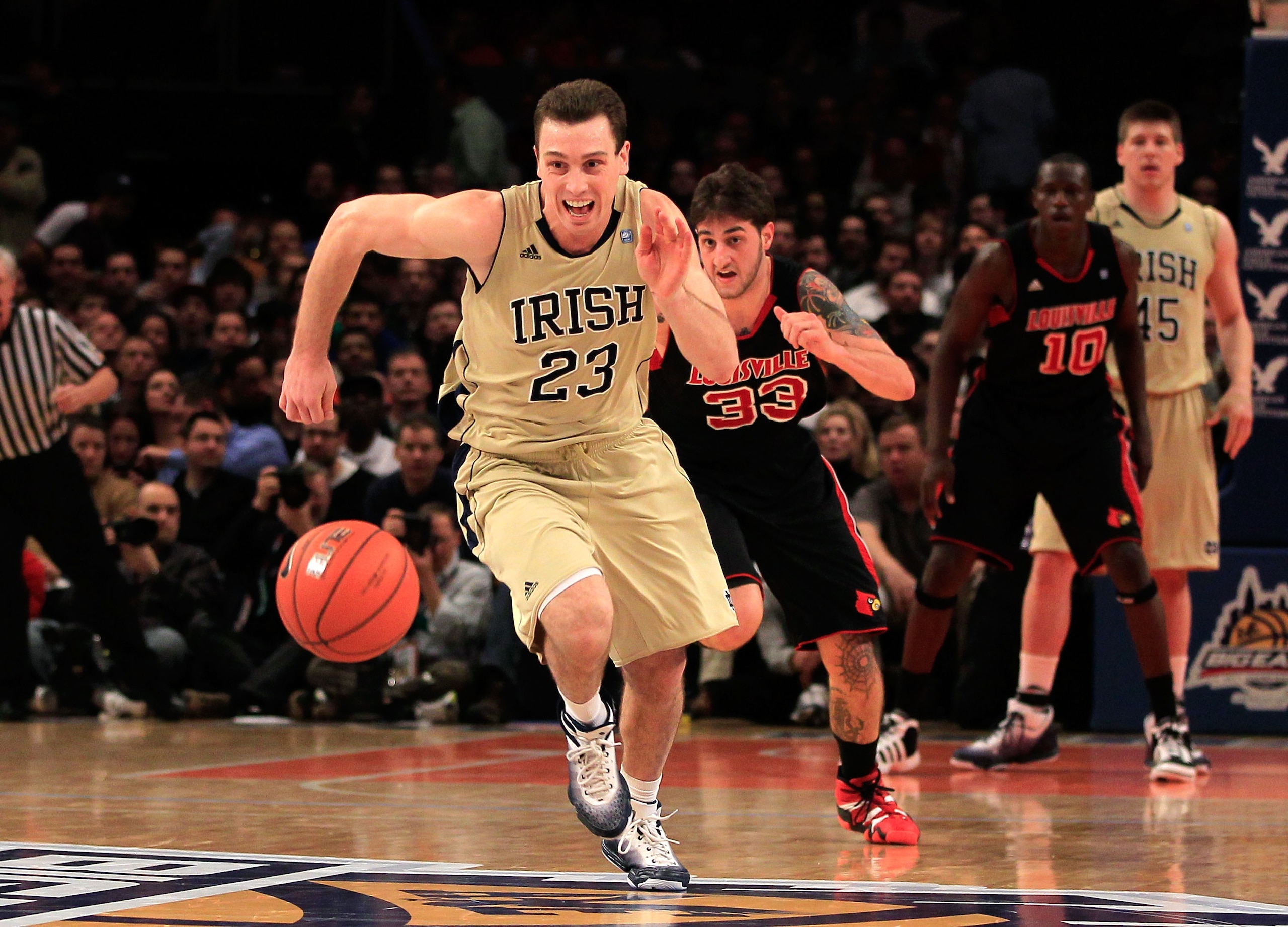 NEW YORK, NY - MARCH 11: Ben Hansbrough #23 of the Notre Dame Fighting Irish chases down a loose ball with Mike Marra #33 of the Louisville Cardinals behind him during the semifinals of the 2011 Big East Men's Basketball Tournament presented by American E