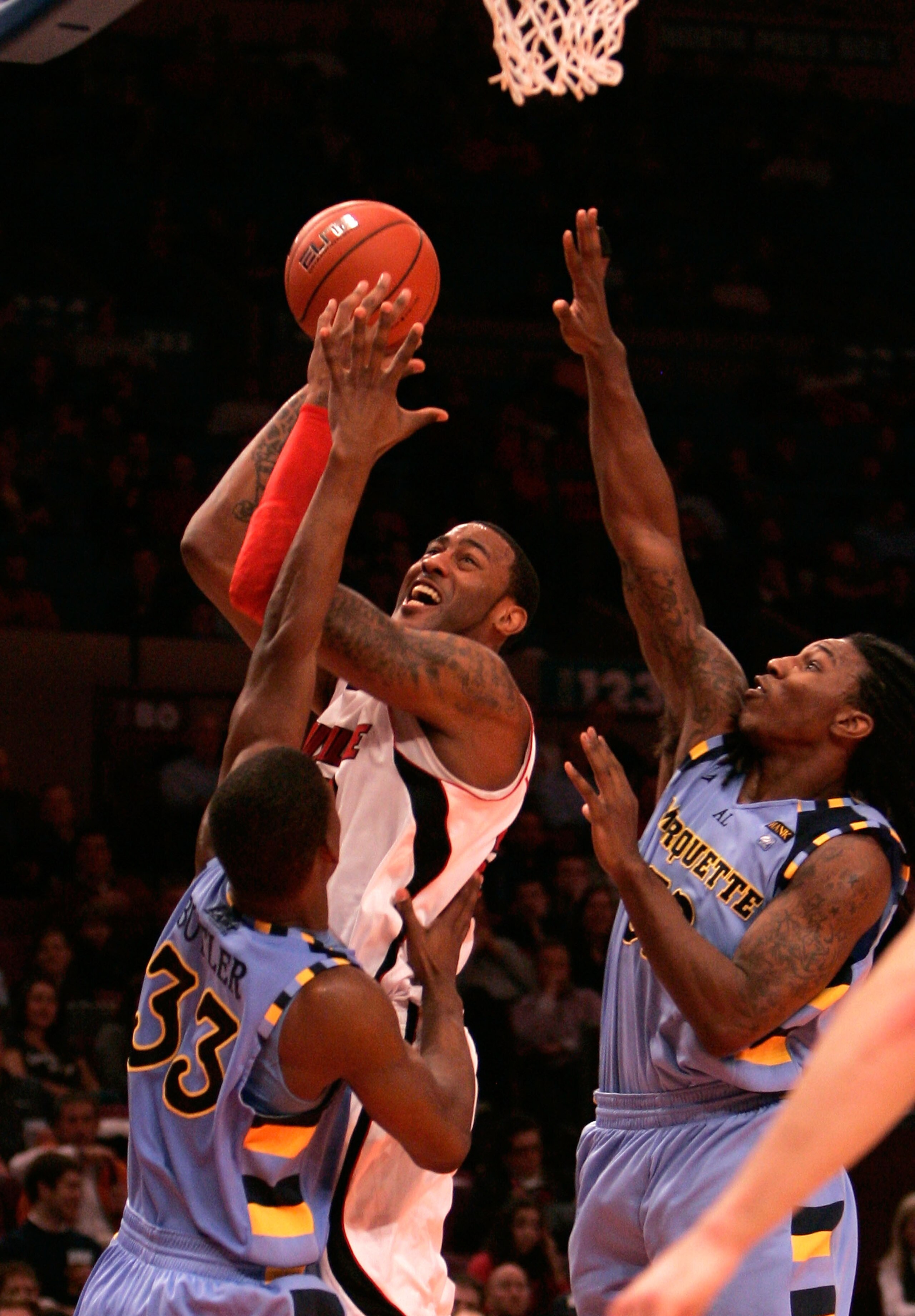 NEW YORK, NY - MARCH 10:  Terrence Jennings #23 of the Louisville Cardinals drives to the basket against Jimmy Butler #33 and Jae Crowder #32 of the Marquette Golden Eagles during the quarterfinals of the 2011 Big East Men's Basketball Tournament presente