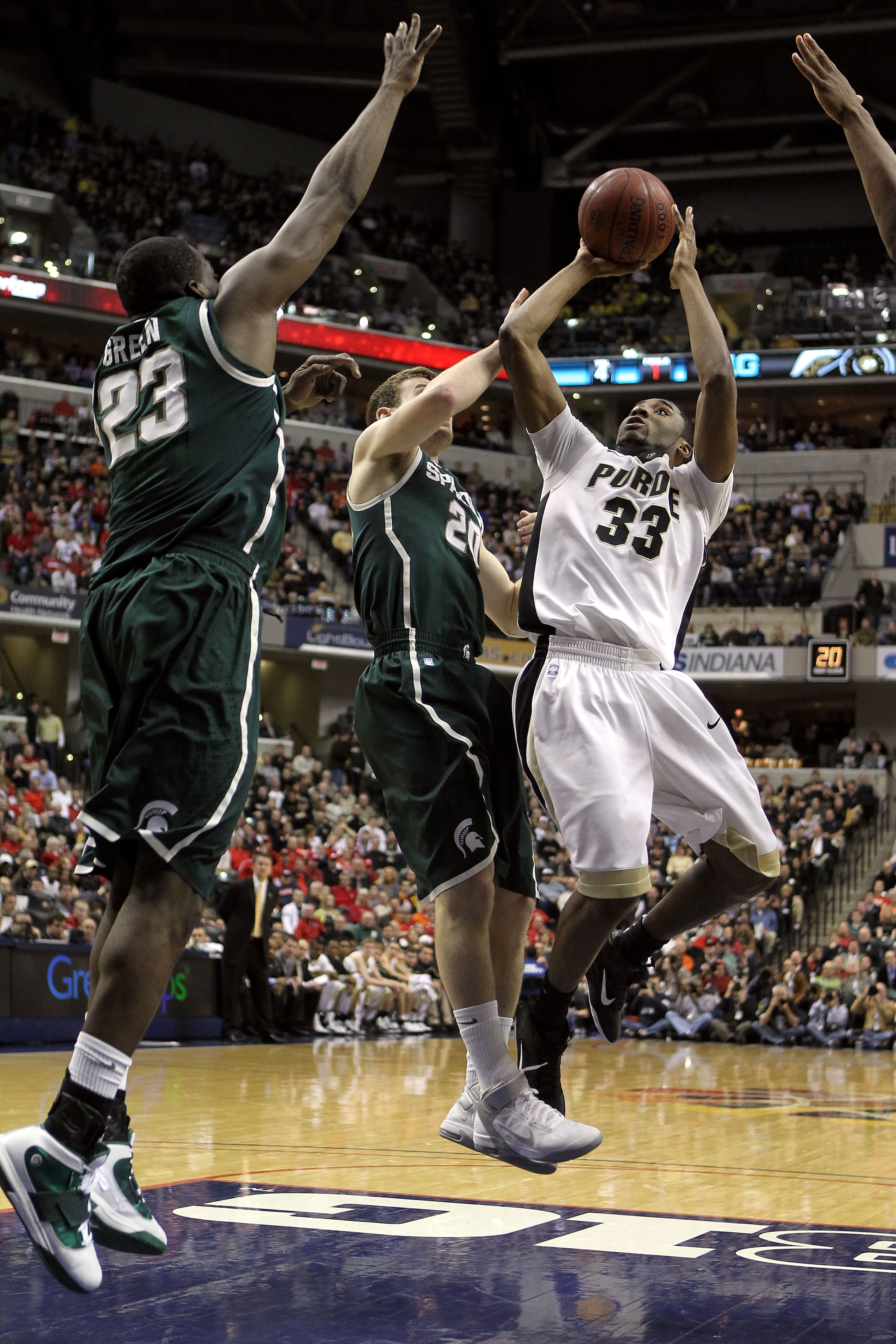 INDIANAPOLIS, IN - MARCH 11:  E'Twaun Moore #33 of the Purdue Boilermakers attempts a shot in the first half against Mike Kebler #20 and Draymond Green #23 of the Michigan State Spartans during the quarterfinals of the 2011 Big Ten Men's Basketball Tourna