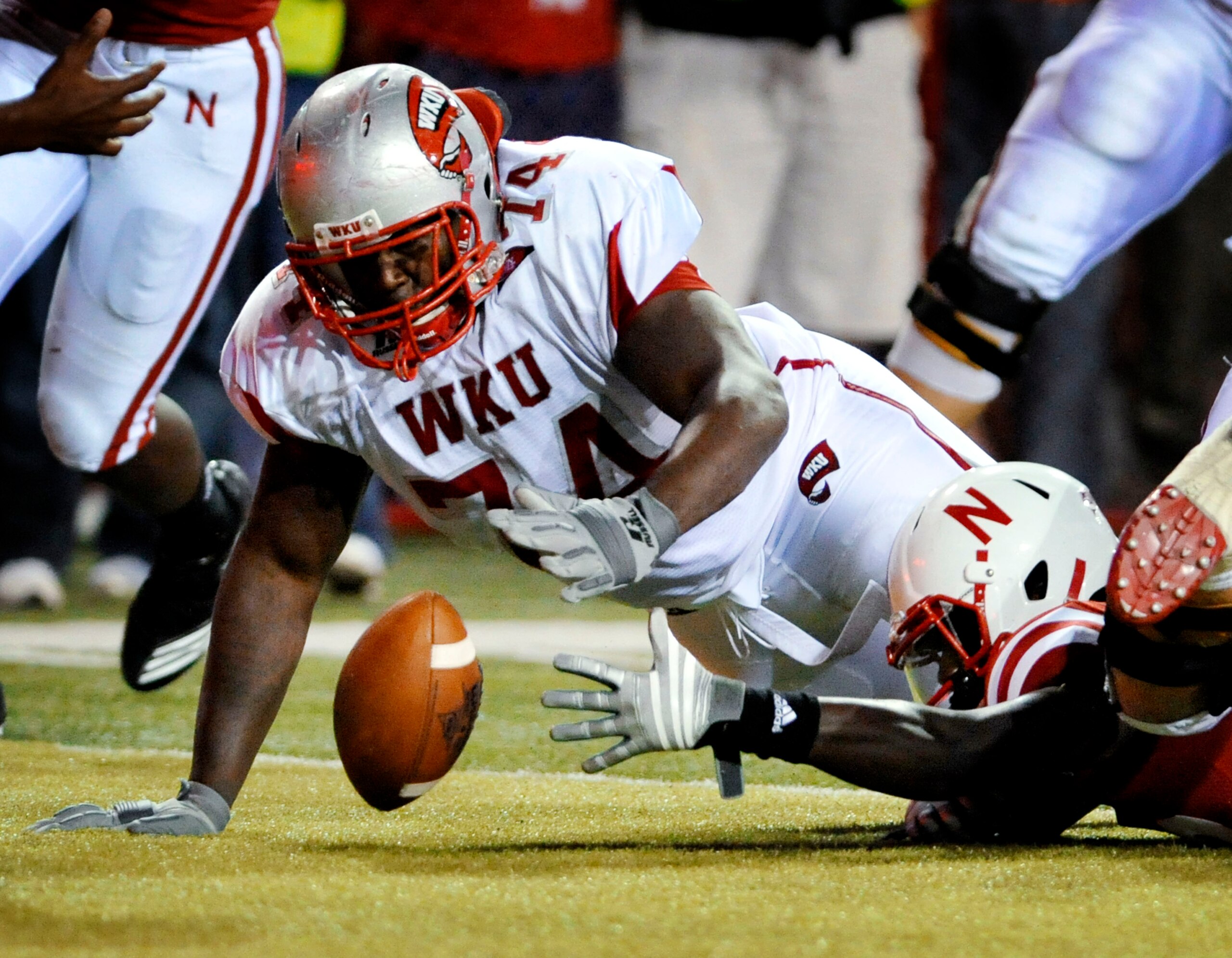 LINCOLN, NE - SEPTEMBER 04: P.J. Smith #13 of the Nebraska Cornhuskers fights for a fumble with Mychal Patterson #74 of the Western Kentucky Hilltoppers during second half action of their game at Memorial Stadium on September 4, 2010 in Lincoln, Nebraska LINCOLN, NE - SEPTEMBER 04: P.J. Smith #13 of the Nebraska Cornhuskers fights for a fumble with Mychal Patterson #74 of the Western Kentucky Hilltoppers during second half action of their game at Memorial Stadium on September 4, 2010 in Lincoln, Nebraska