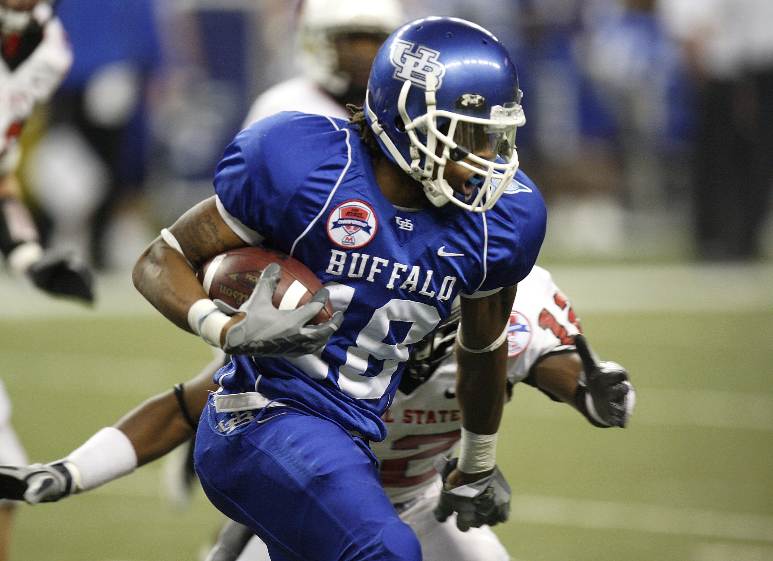 DETROIT - DECEMBER 05: Naaman Roosevelt #18 of the Buffalo Bulls tries to get around the tackle of Trey Lewis #12 of the Ball State Cardinals during the second quarter of the MAC Championship game on December 5, 2008 at Ford Field in Detroit, Michigan. ( DETROIT - DECEMBER 05: Naaman Roosevelt #18 of the Buffalo Bulls tries to get around the tackle of Trey Lewis #12 of the Ball State Cardinals during the second quarter of the MAC Championship game on December 5, 2008 at Ford Field in Detroit, Michigan. (