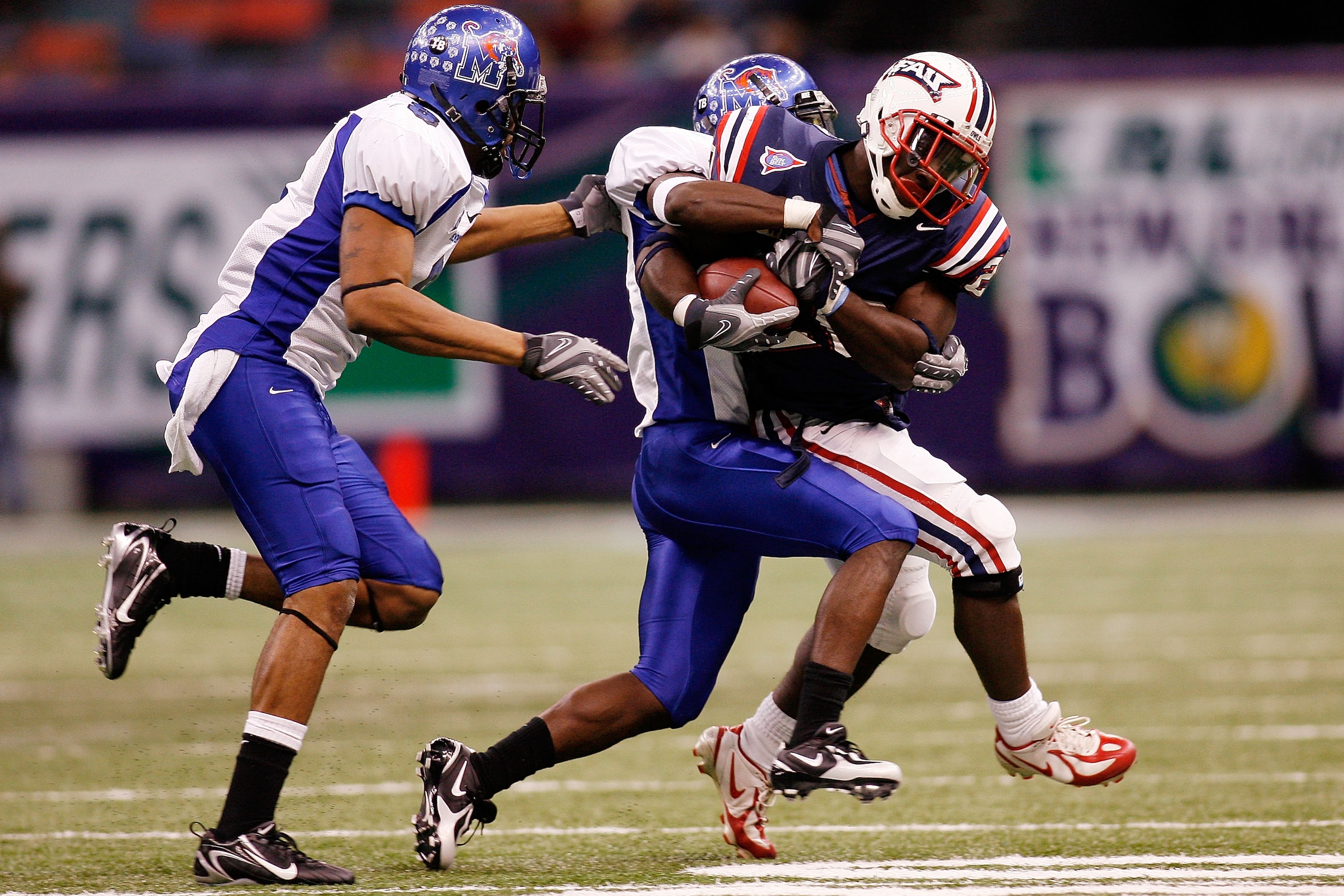 NEW ORLEANS - DECEMBER 21: Charles Pierre #20 of the Florida Atlantic University Owls is tackled by LaKeitharun Ford #18 and Tony Bell #8 of the Memphis University Tigers in the New Orleans Bowl on December 21, 2007 at the Louisiana Superdome in New Orl NEW ORLEANS - DECEMBER 21: Charles Pierre #20 of the Florida Atlantic University Owls is tackled by LaKeitharun Ford #18 and Tony Bell #8 of the Memphis University Tigers in the New Orleans Bowl on December 21, 2007 at the Louisiana Superdome in New Orl