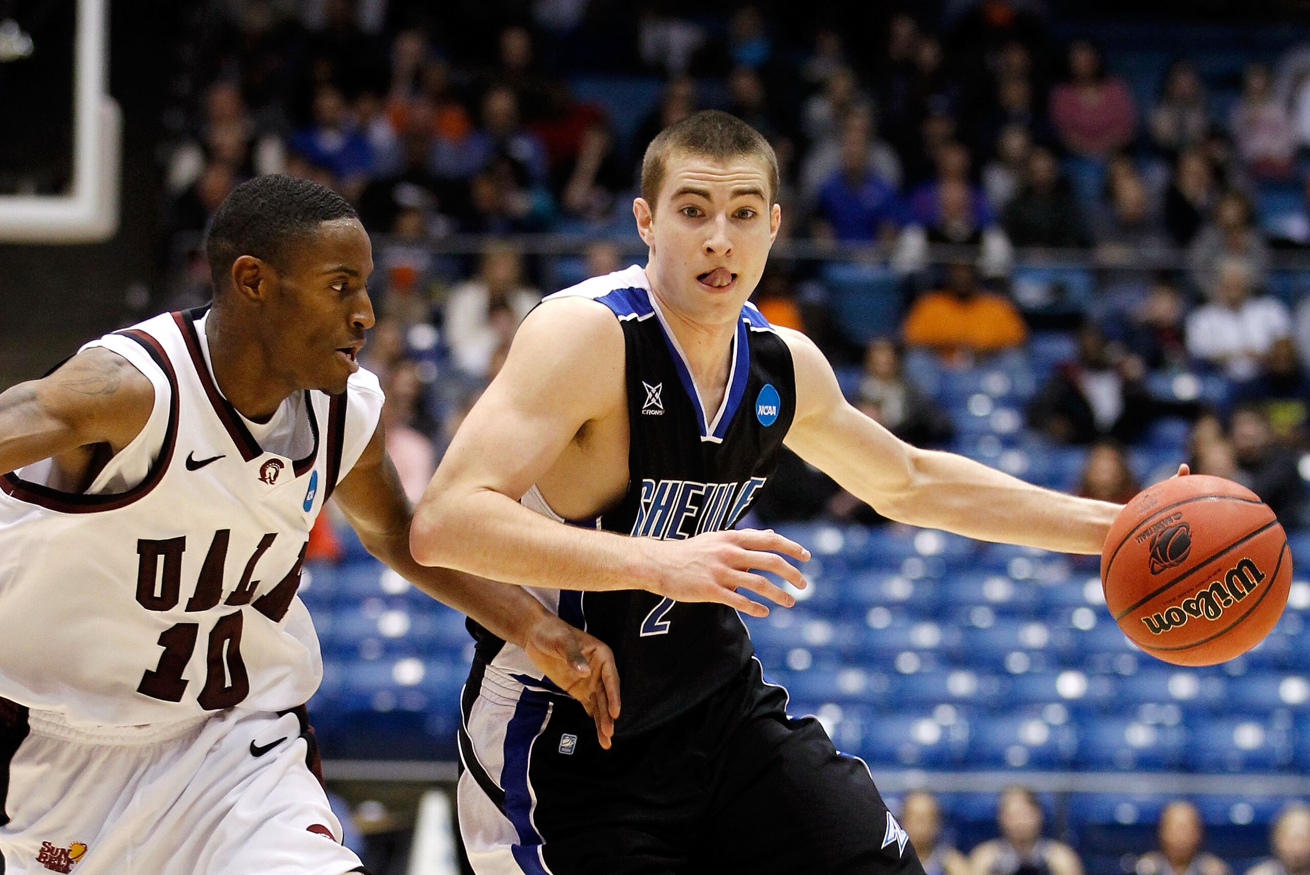 DAYTON, OH - MARCH 15: Matt Dickey #2 of the North Carolina-Asheville Bulldogs brings the ball up court against D'Andre Williams #10 of the Arkansas Little Rock Trojans during the first round of the 2011 NCAA men's basketball tournament at UD Arena on Mar