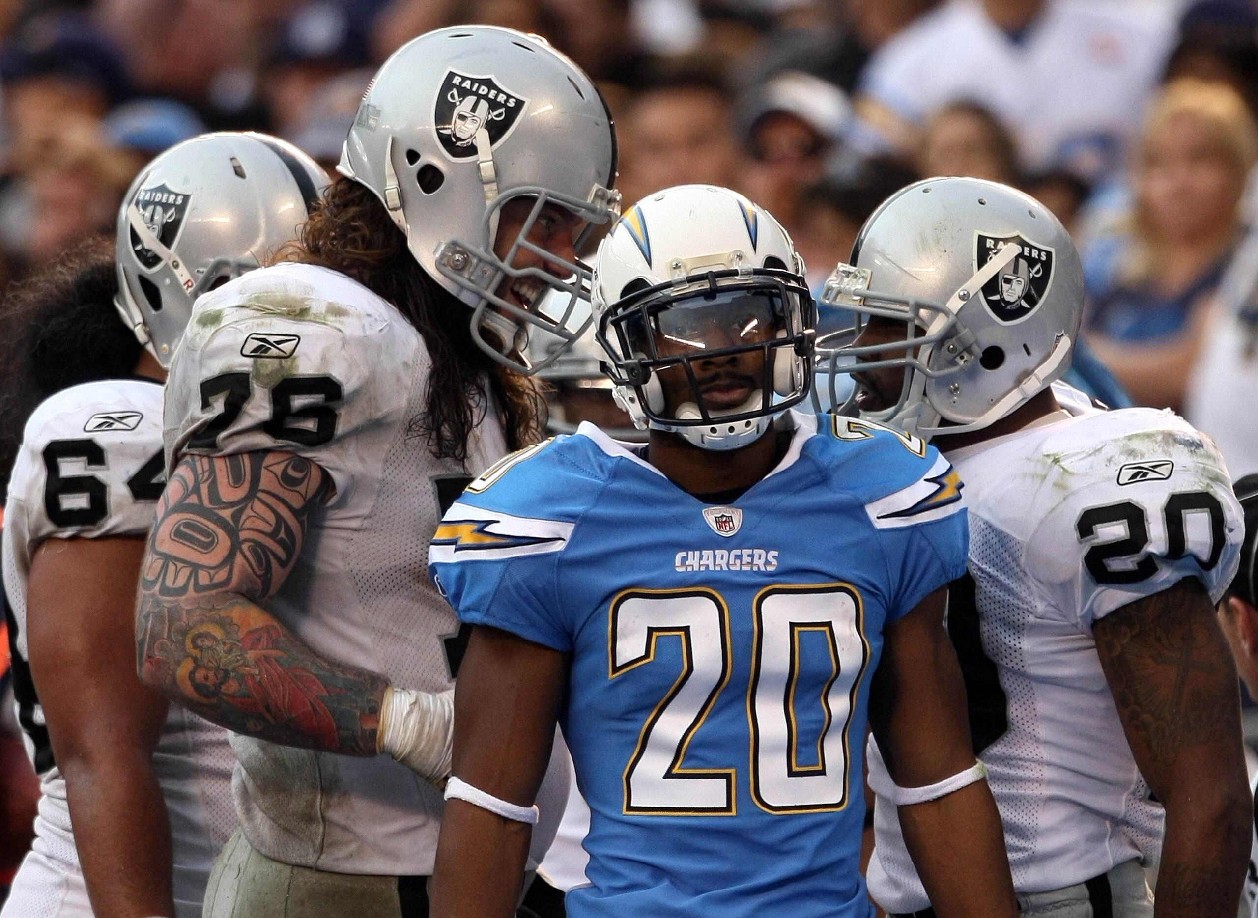 SAN DIEGO, CA - DECEMBER 5: Antoine Cason #20 of the San Diego Chargers looks on as Robert Gallery #76 congratulates teammate Darren McFadden #20 of the Oakland Raiders after McFadden's touchdown during their NFL game at Qualcomm Stadium on December 5, 20