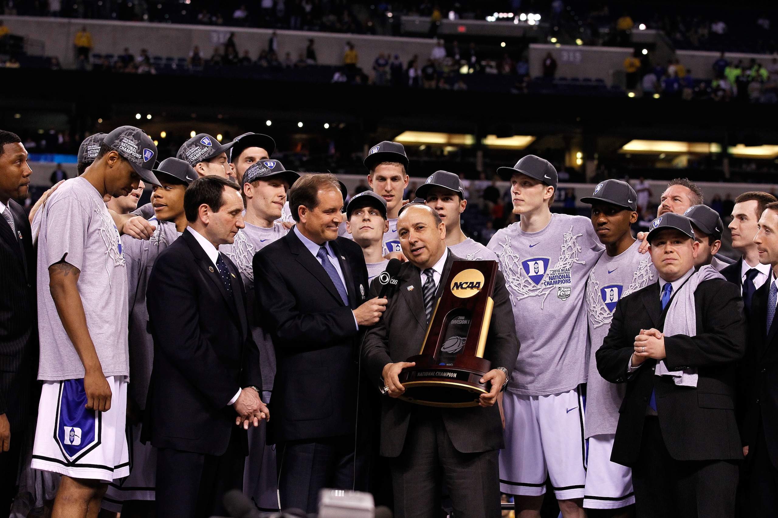 INDIANAPOLIS - APRIL 05:  Head coach Mike Krzyzewski of the Duke Blue Devils receives the trophy as his players celebrate after they won 61-59 against the Butler Bulldogs during the 2010 NCAA Division I Men's Basketball National Championship game at Lucas