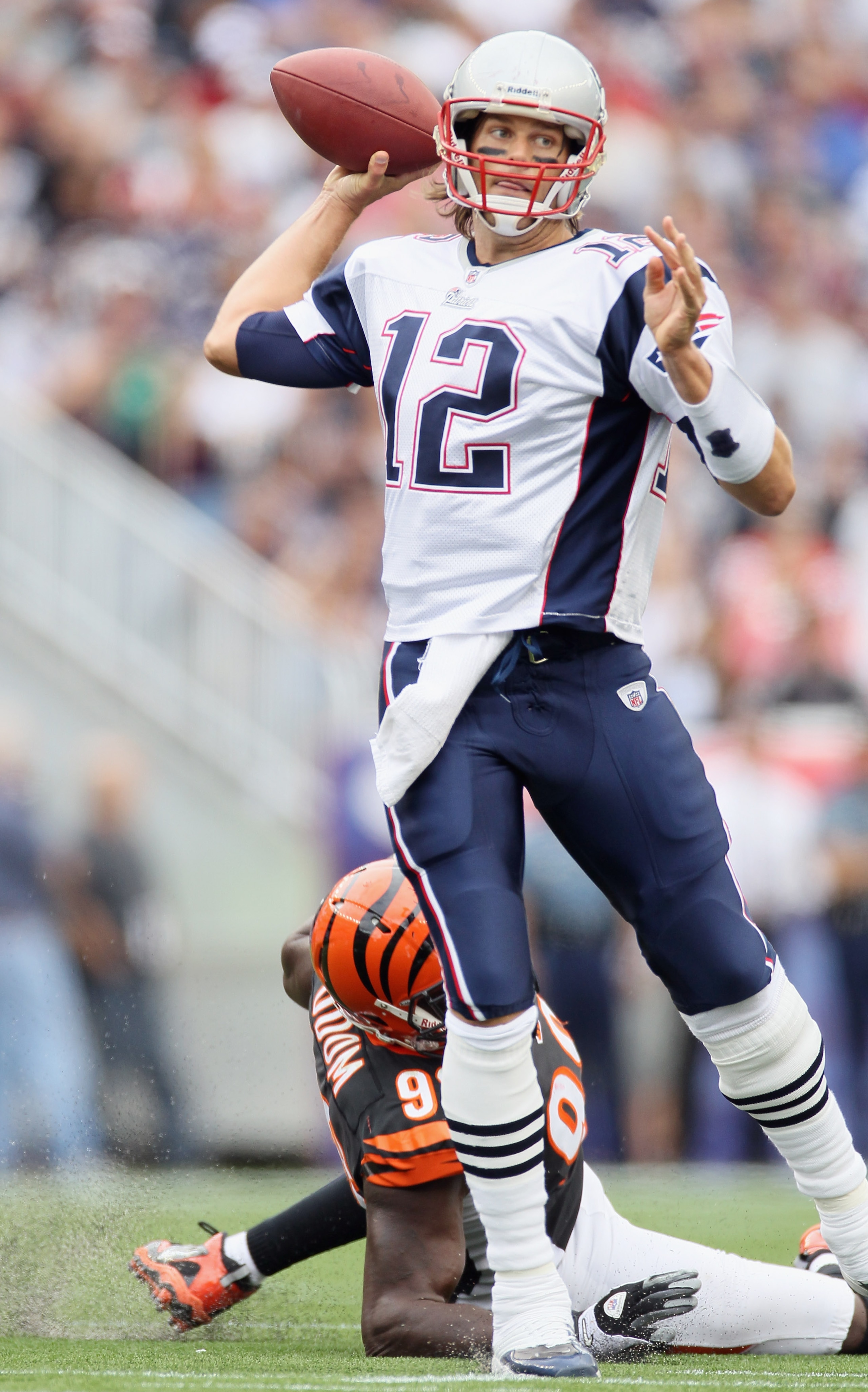 FOXBORO, MA - SEPTEMBER 12:  Tom Brady #12 of the New England Patriots scrambles as Antwan Odom #98 of the Cincinnati Bengals is unable to make the sack during the NFL season opener on September 12, 2010 at Gillette Stadium in Foxboro, Massachusetts.  (Ph