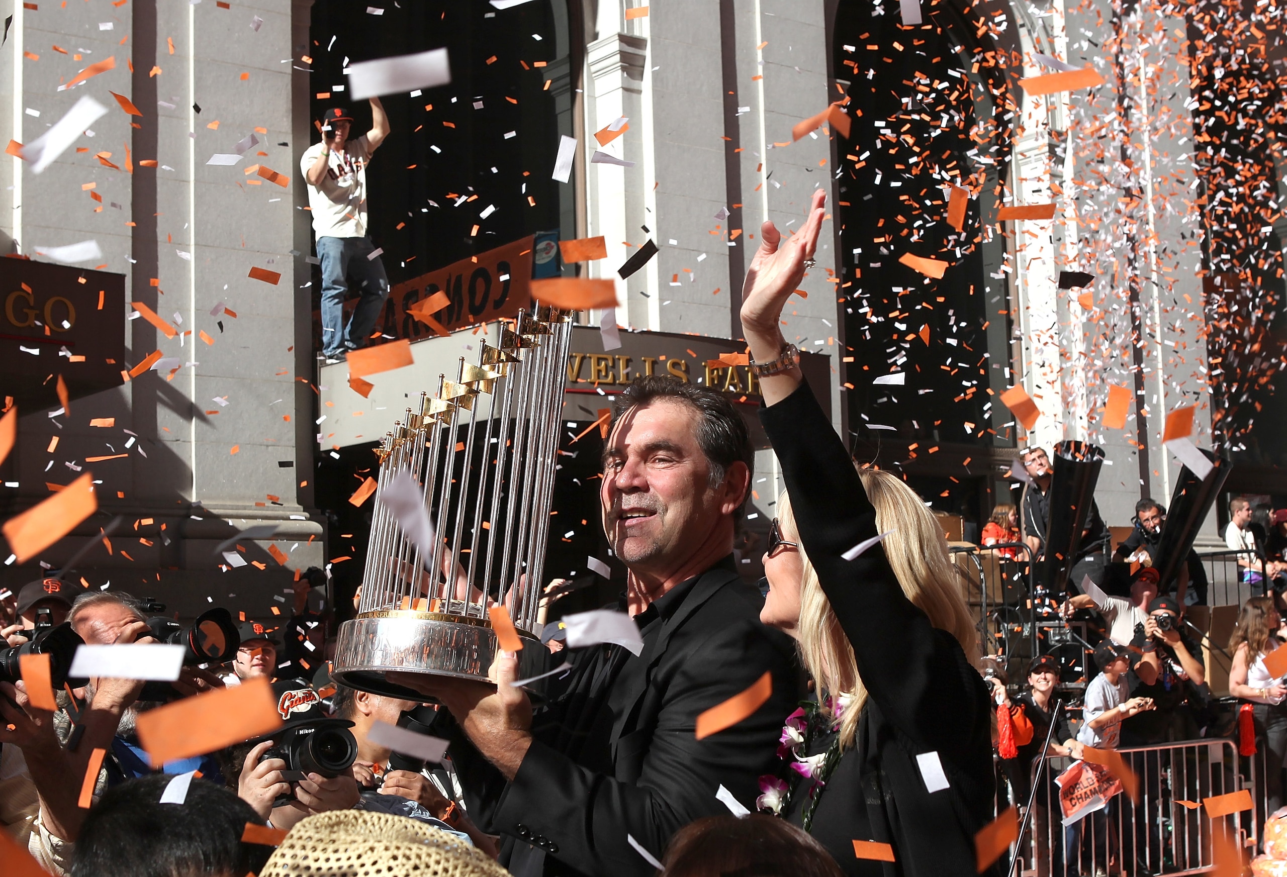 SAN FRANCISCO - NOVEMBER 03:  San Francisco Giants manager Bruce Bochy carries the World Series trophy as he rides in a vintage car during the Giants' vicotry parade on November 3, 2010 in San Francisco, California. Thousands of Giants fans lined the stre