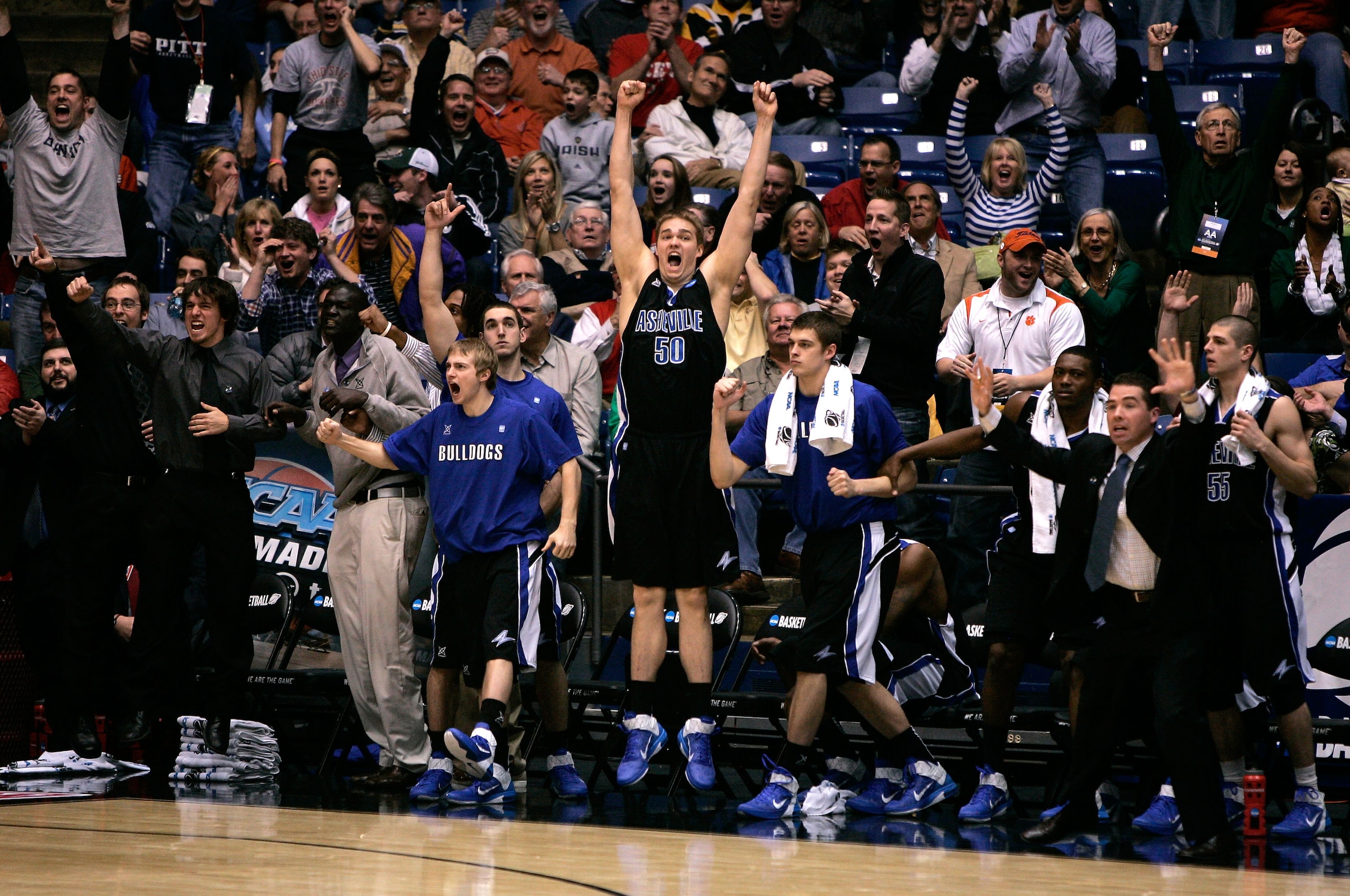 DAYTON, OH - MARCH 15: Jeremy Harn #50 of the North Carolina-Asheville Bulldogs and the teams bench celebrate after Matt Dickey #2 makes a game typing basket late in the second half sending the game to overtime against the Arkansas Little Rock Trojans dur