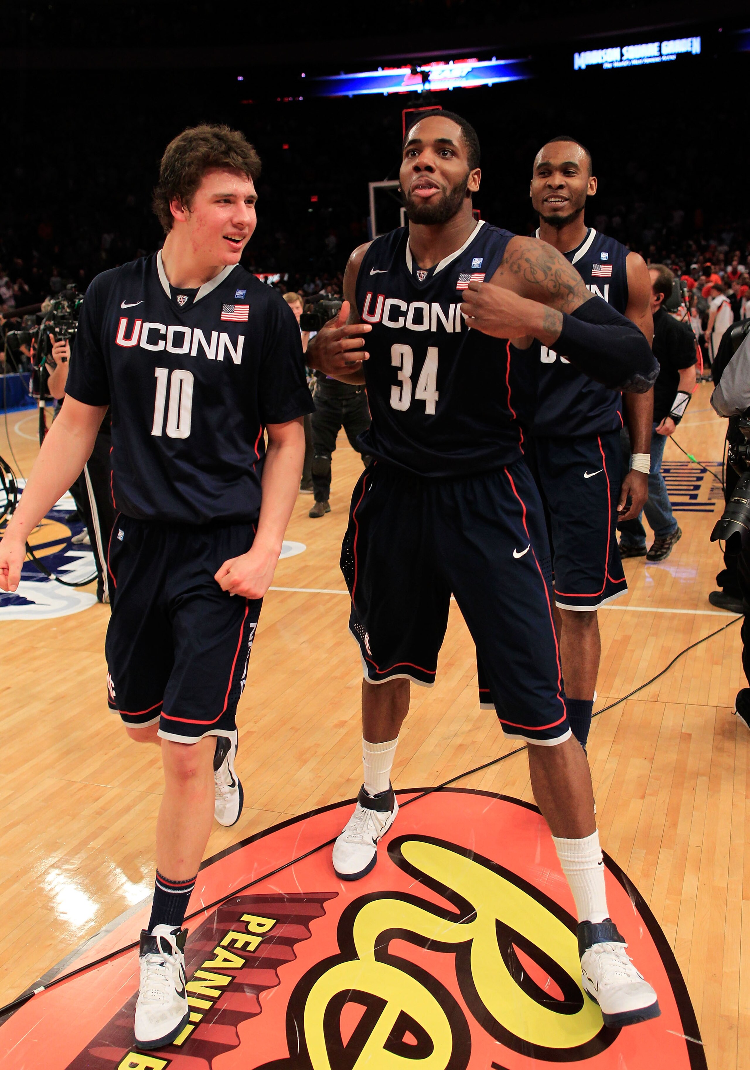 NEW YORK, NY - MARCH 11: Tyler Olander #10, Alex Oriakhi #34 and Charles Okwandu #35 of the Connecticut Huskies celebrate after defeating the Syracuse Orange during the semifinals of the 2011 Big East Men's Basketball Tournament presented by American Eagl NEW YORK, NY - MARCH 11: Tyler Olander #10, Alex Oriakhi #34 and Charles Okwandu #35 of the Connecticut Huskies celebrate after defeating the Syracuse Orange during the semifinals of the 2011 Big East Men's Basketball Tournament presented by American Eagl