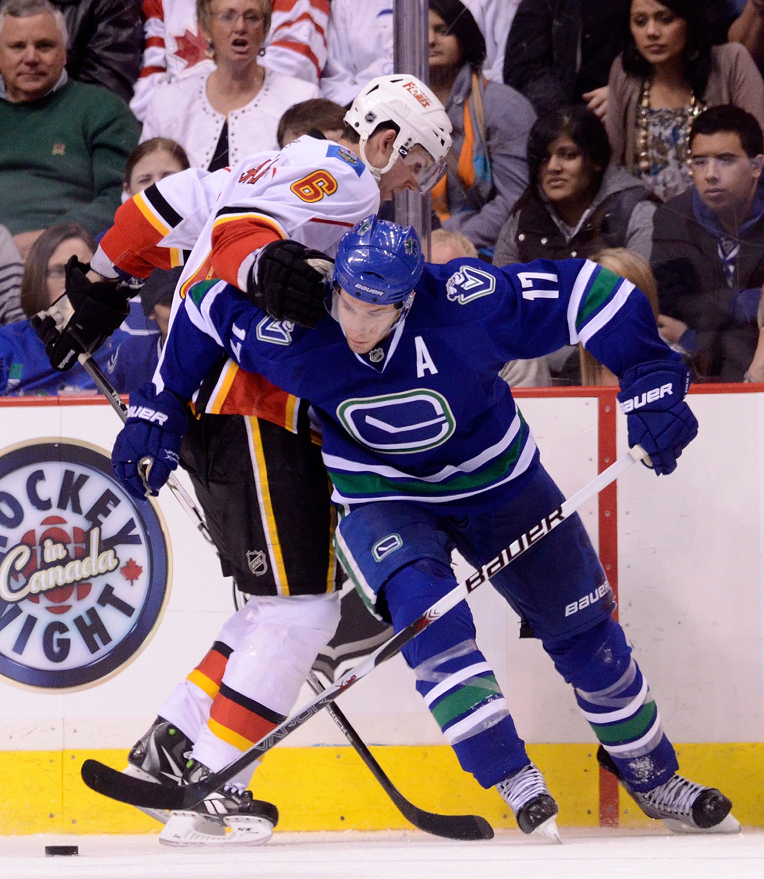 VANCOUVER, CANADA - FEBRUARY 12: Ryan Kesler #17 of the Vancouver Canucks tries to break free from Cory Sarich #6 of the Calgary Flames while battling for the loose puck during the third period in NHL action on February 12, 2011 at Rogers Arena in Vancouv