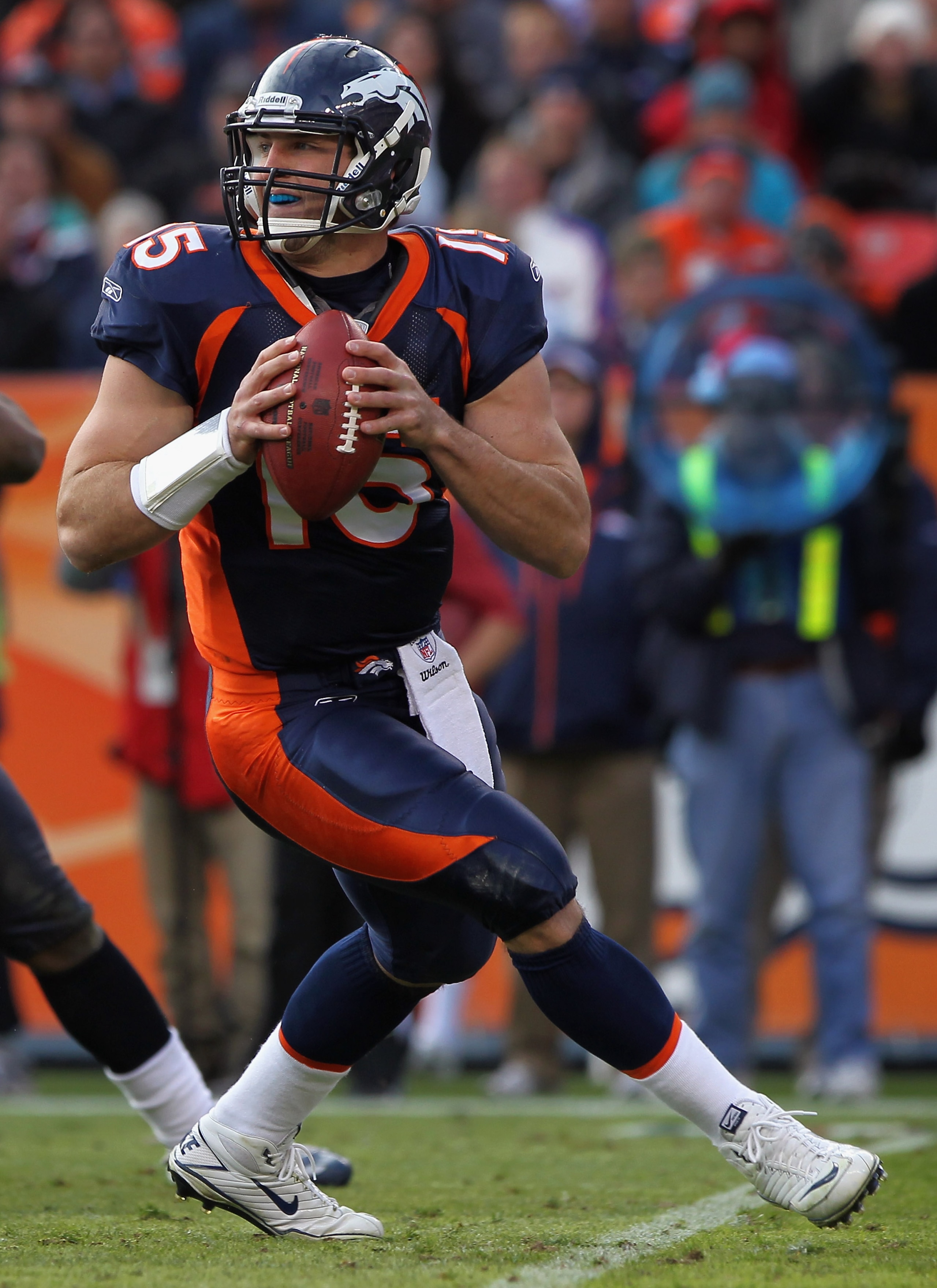 DENVER - DECEMBER 26: Quarterback Tim Tebow #15 of the Denver Broncos rolls out and looks to deliver a pass against the Houston Texas at INVESCO Field at Mile High on December 26, 2010 in Denver, Colorado. The Broncos defeated the Texans 24-23. (Photo b DENVER - DECEMBER 26: Quarterback Tim Tebow #15 of the Denver Broncos rolls out and looks to deliver a pass against the Houston Texas at INVESCO Field at Mile High on December 26, 2010 in Denver, Colorado. The Broncos defeated the Texans 24-23. (Photo b