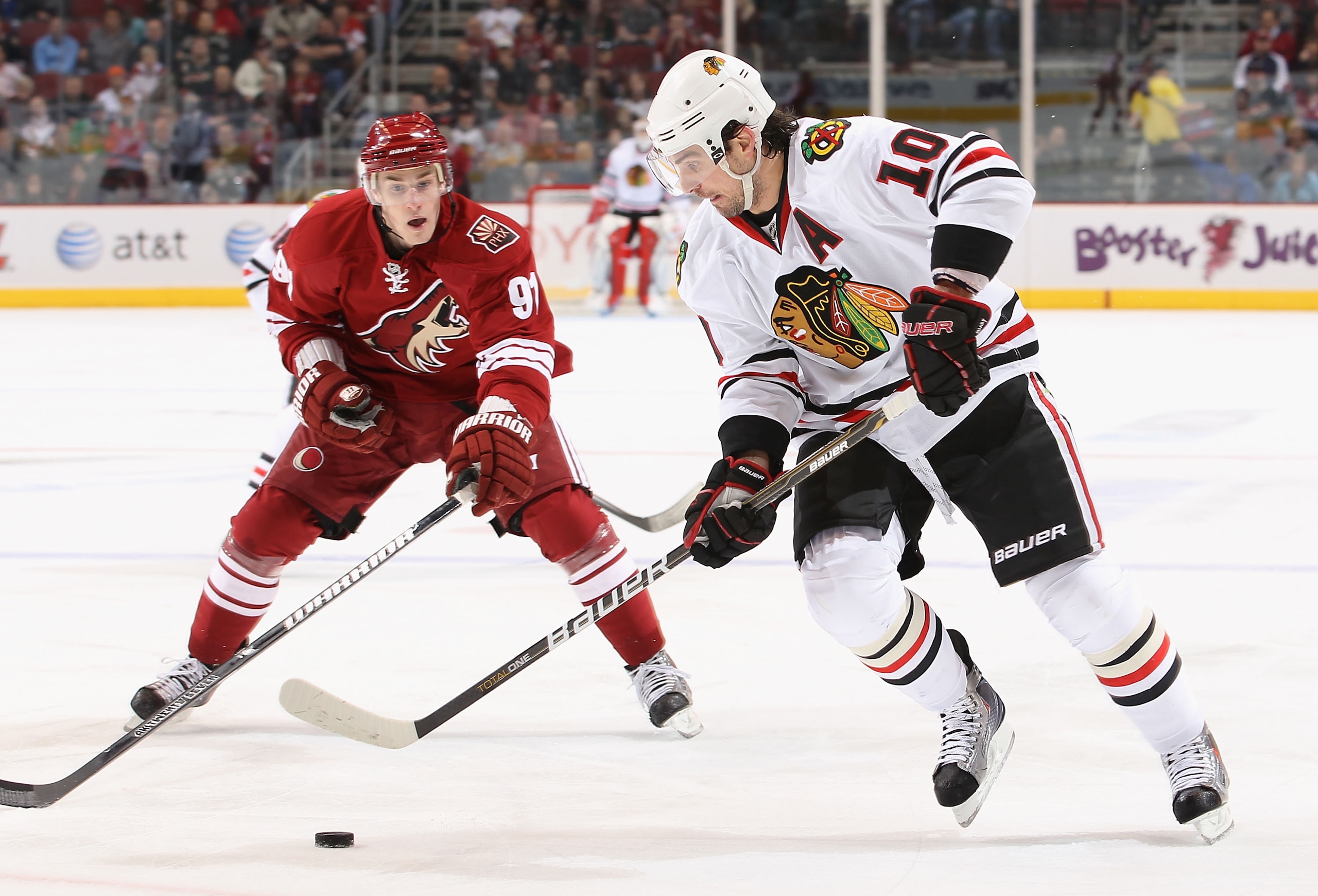 GLENDALE, AZ - FEBRUARY 12:  Patrick Sharp #10 of the Chicago Blackhawks skates with the puck under pressure from Kyle Turris #91 of the Phoenix Coyotes during the NHL game at Jobing.com Arena on February 12, 2011 in Glendale, Arizona. The Coyotes defeate